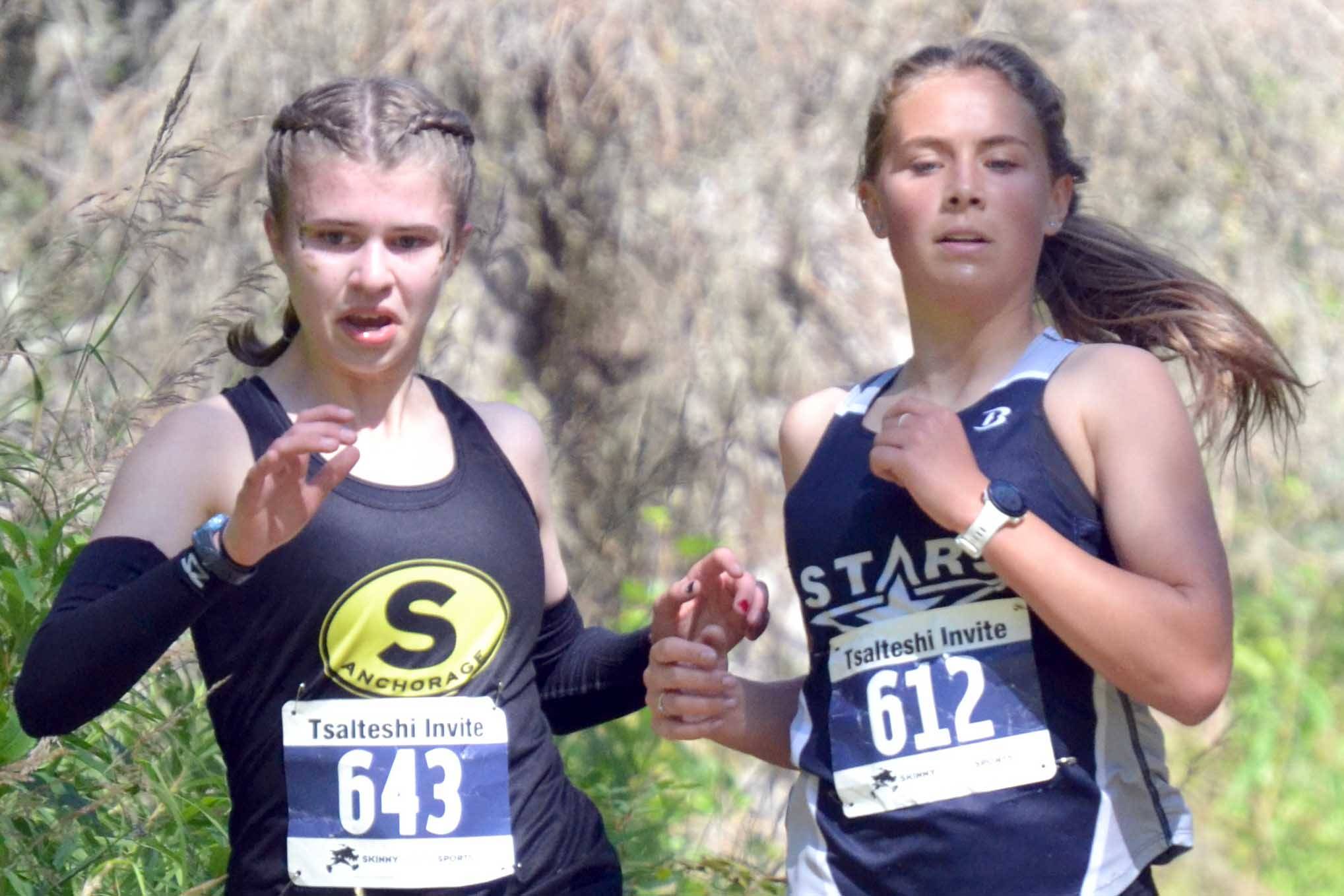 Soldotna's Jordan Strausbaugh races to 17th place in the girls varsity race at the Ted McKenney XC Invitational on Saturday, Aug. 21, 2021, at Tsalteshi Trails just outside of Soldotna, Alaska. "We run for Ted" is written on Strausbaugh's thigh in honor of former Soldotna coach Ted McKenney. Strausbaugh runs with South's Elizabeth Page and Eagle River's Ava Trembath. (Photo by Jeff Helminiak/Peninsula Clarion)