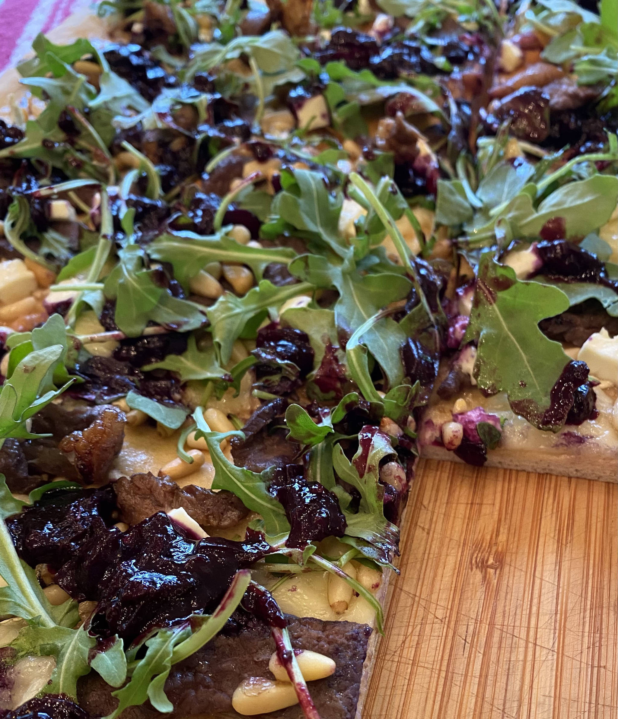 Arugula, pine nuts, and the blueberry relish top meats and homemade pizza dough. (Photo by Tress Dale/Peninsula Clarion)