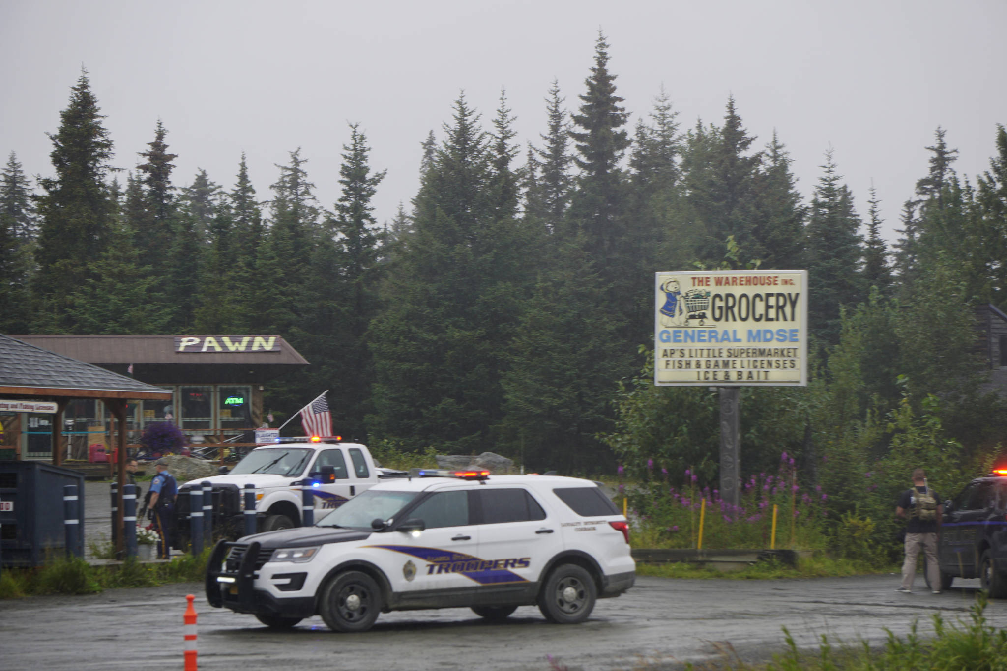 Alaska State Troopers investigate a shooting scene on Monday, Aug. 23, 2021, at the Anchor Point Warehouse in Anchor Point, Alaska at the store on the Sterling Highway in which an Alaska State Trooper was shot. Troopers were searching for the alleged shooter, Bret Herrick, 60. (Photo by Michael Armstrong/Homer News)