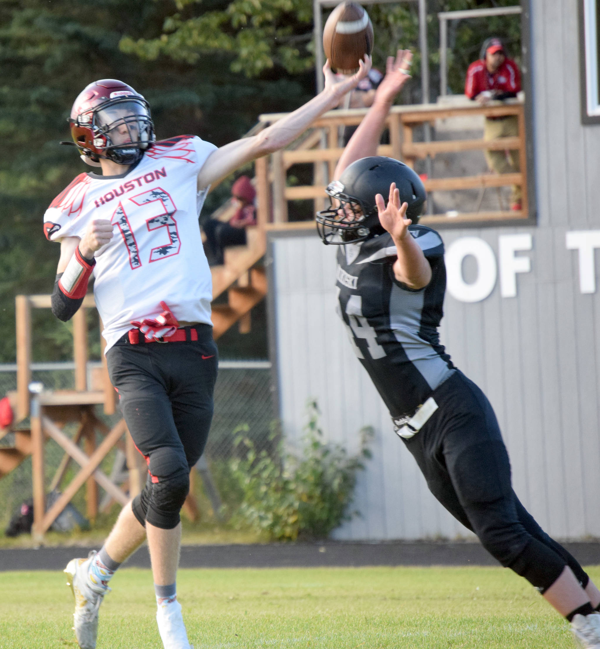 Houston quarterback Colton Bunn gets off a pass under pressure from Nikiski’s Truit McCaughey on Friday, Aug. 27, 2021, at Nikiski High School in Nikiski, Alaska. (Photo by Jeff Helminiak/Peninsula Clarion)