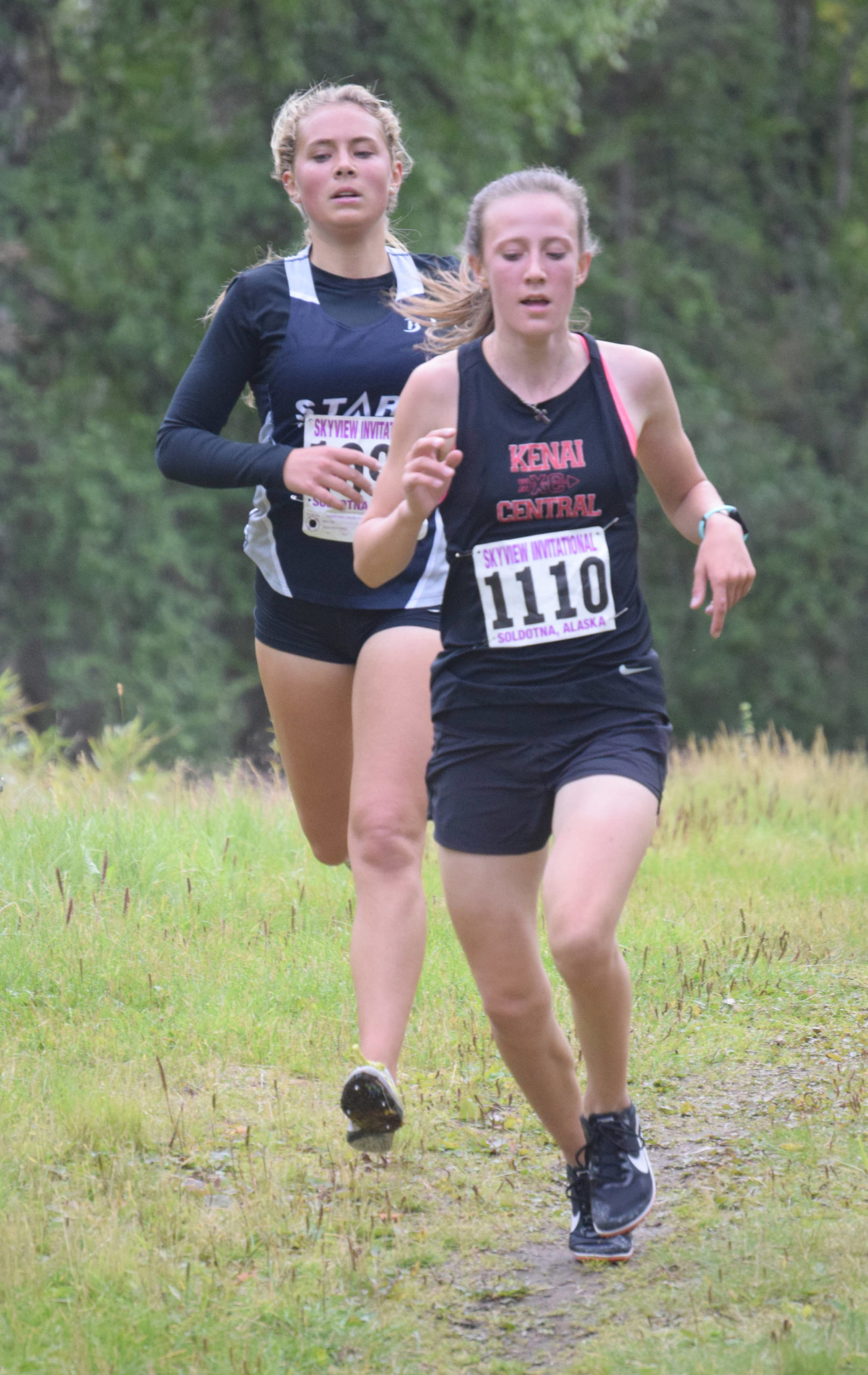 Soldotna’s Jordan Strausbaugh tries to find a way around Kenai Central’s Jayna Boonstra on Wednesday, Sept. 1, 2021, at the Kenai-Soldotna dual meet at Tsalteshi Trails just outside of Soldotna, Alaska. Boonstra was able to hang on for first place in the race. (Photo by Jeff Helminiak/Peninsula Clarion)