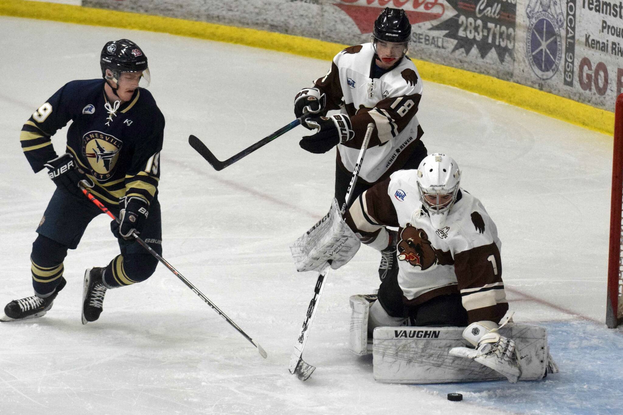 Kenai River Brown Bears goalie Luke Pavicich covers up the puck in front of Shane Ott of the Janesville (Wisconsin) Jets as Brown Bears defenseman Brendan Hill looks on Thursday, April 29, 2021, at the Soldotna Regional Sports Complex in Soldotna, Alaska. (Photo by Jeff Helminiak/Peninsula Clarion)