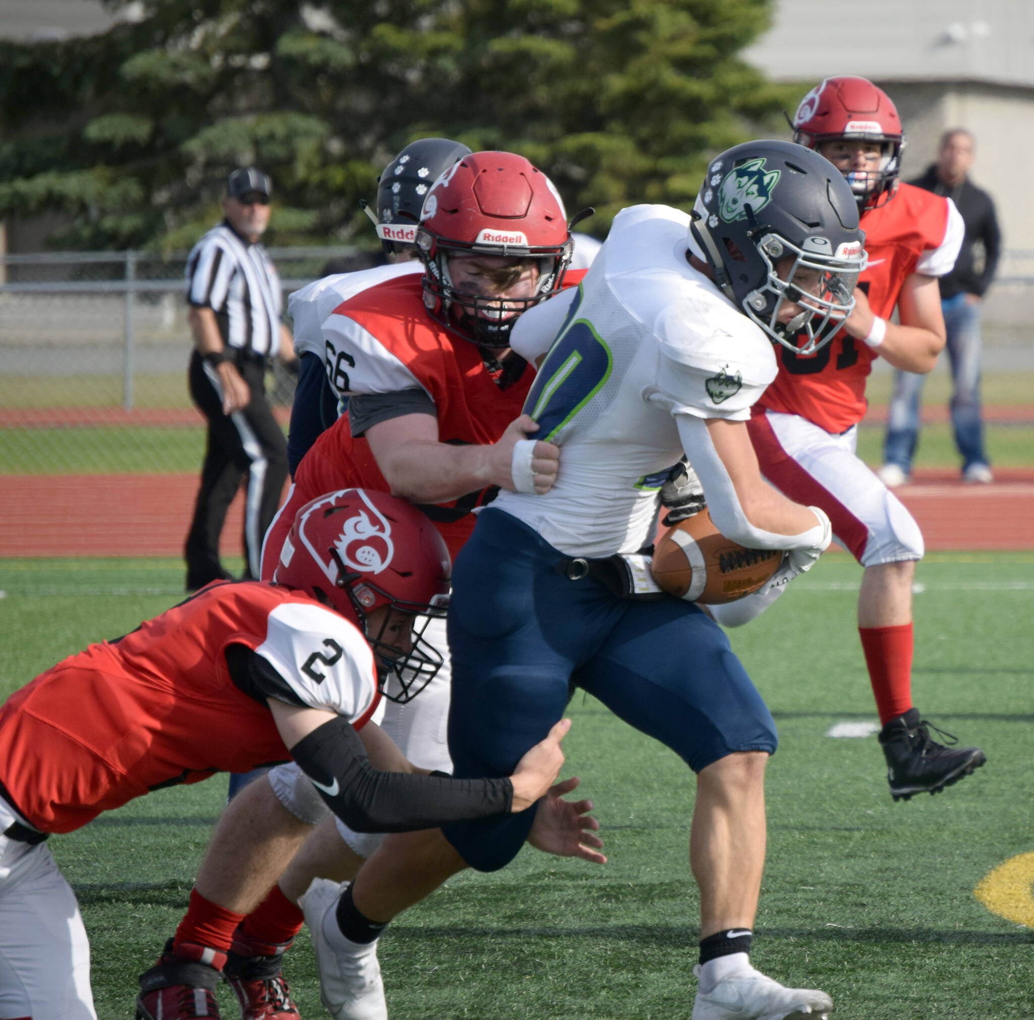 Redington’s Jaden Spaulding slips between two Kardinals for a gain Saturday, Sept. 11, 2021, at Kenai Central High School in Kenai, Alaska. (Photo by Jeff Helminiak/Peninsula Clarion)