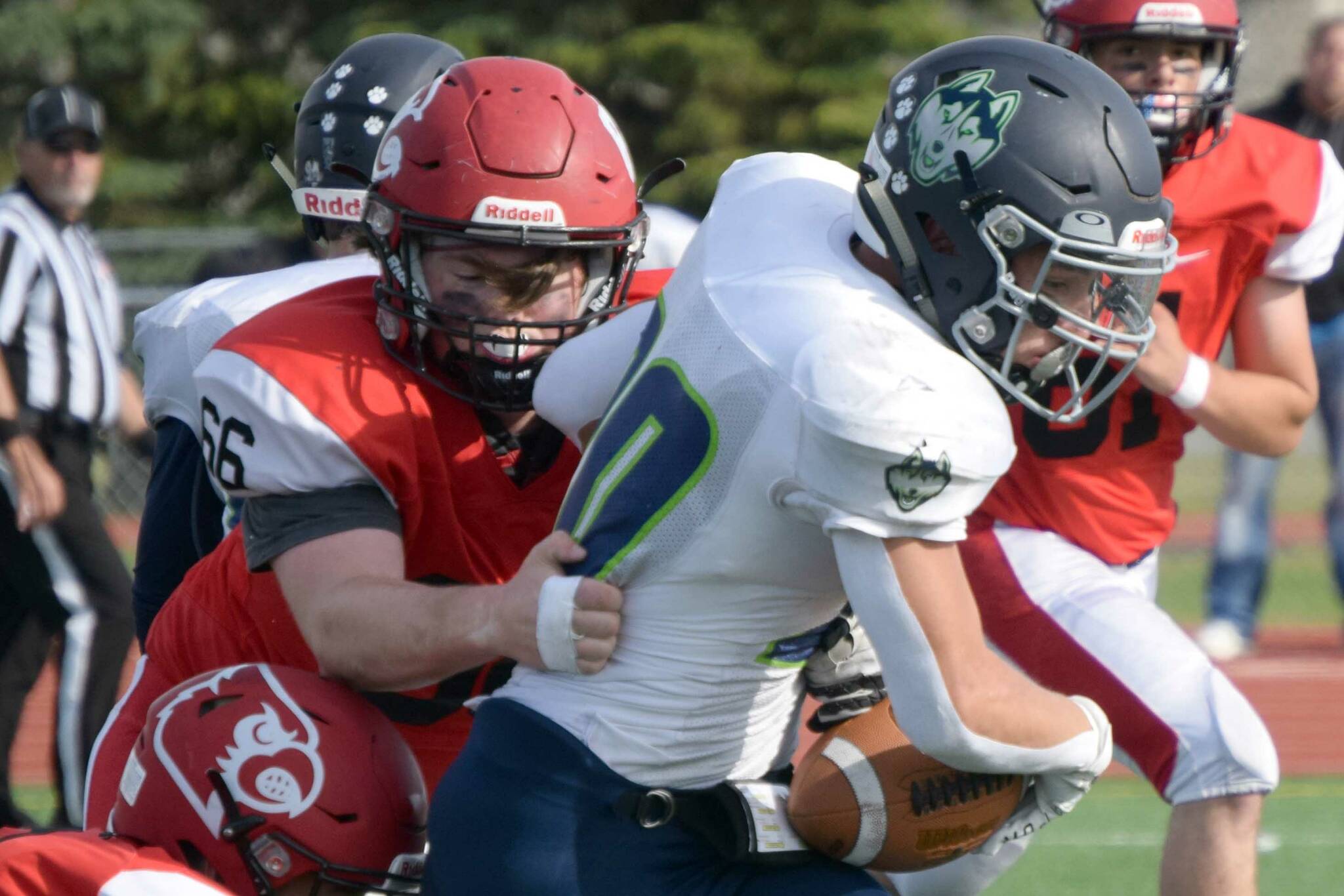 Redington's Jaden Spaulding slips between two Kardinals for a gain Saturday, Sept. 11, 2021, at Kenai Central High School in Kenai, Alaska. (Photo by Jeff Helminiak/Peninsula Clarion)