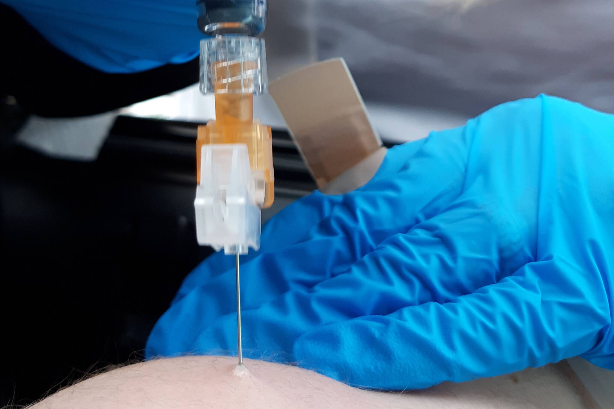 Chelsea Berg, a nurse at Peninsula Community Health Services, administers a flu shot during a free drive-thru flu shot event at Kenai Central High School on Oct. 24, 2020. (Photo by Brian Mazurek/Peninsula Clarion)