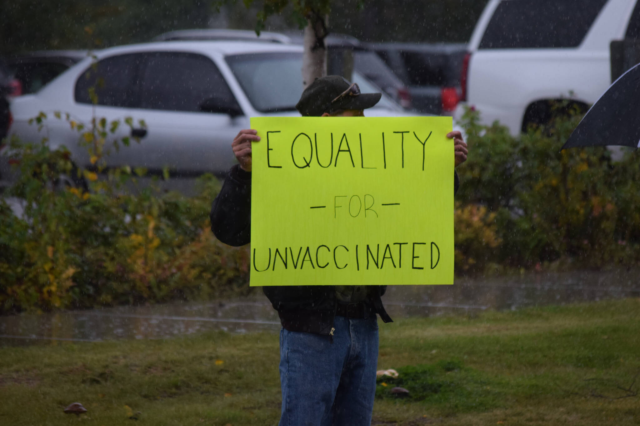A protester stands outside the George A. Navarre Borough Admin building in Soldotna on Tuesday, Sept. 14, 2021. (Camille Botello/Peninsula Clarion)