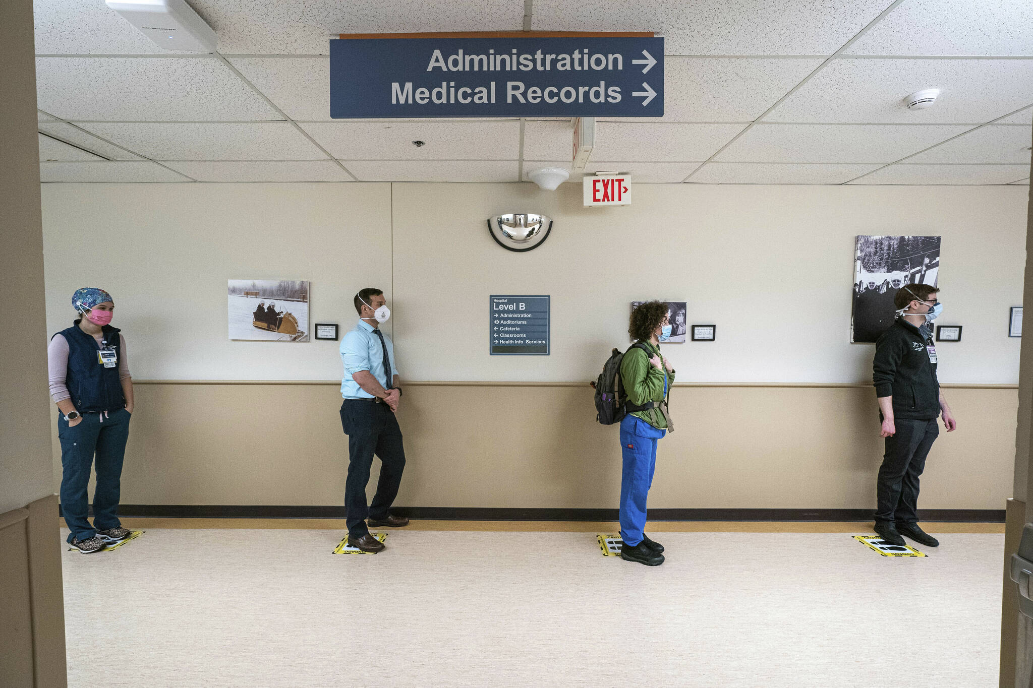 In this Wednesday, Dec. 16, 2020, file photo, front-line caregivers wait in line to receive a Pfizer COVID-19 vaccine at Providence Alaska Medical Center in Anchorage, Alaska. Overwhelmed by a surge in COVID-19 patients, Providence Alaska Medical Center, Alaska’s largest hospital, on Tuesday, Sept. 14, 2021, implemented crisis standards of care, prioritizing resources and treatments to those patients who have the potential to benefit the most. (Loren Holmes/Anchorage Daily News via AP, File)