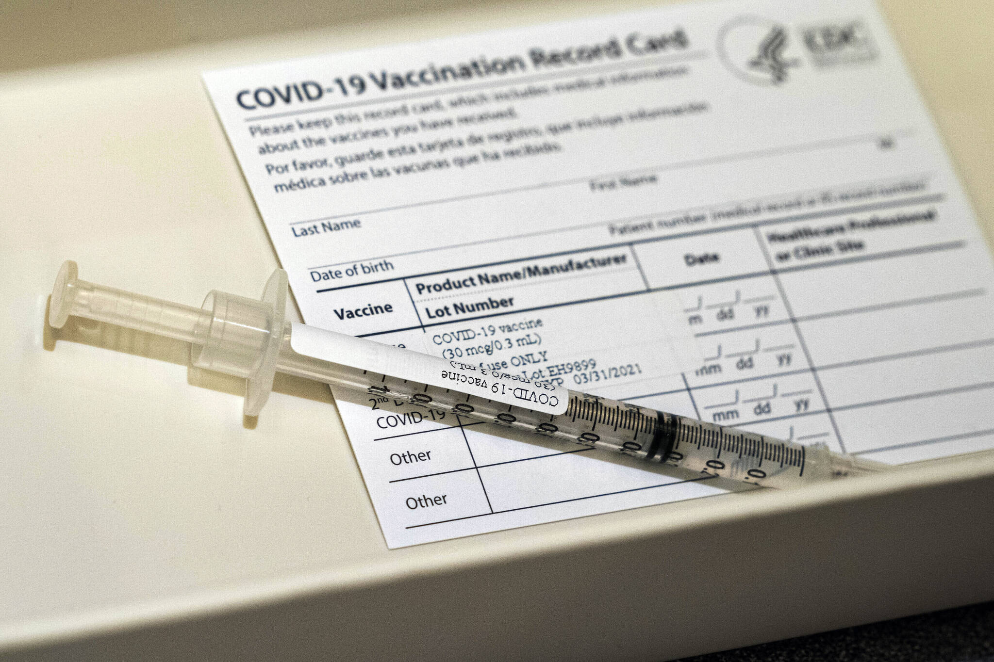 In this Wednesday, Dec. 16, 2020, file photo, a syringe containing a dose of the Pfizer COVID-19 vaccine sits in a container during a vaccine clinic at Providence Alaska Medical Center in Anchorage, Alaska. Overwhelmed by a surge in COVID-19 patients, Providence Alaska Medical Center, Alaska’s largest hospital, on Tuesday, Sept. 14, 2021, implemented crisis standards of care, prioritizing resources and treatments to those patients who have the potential to benefit the most.(Loren Holmes/Anchorage Daily News via AP, Pool, File)