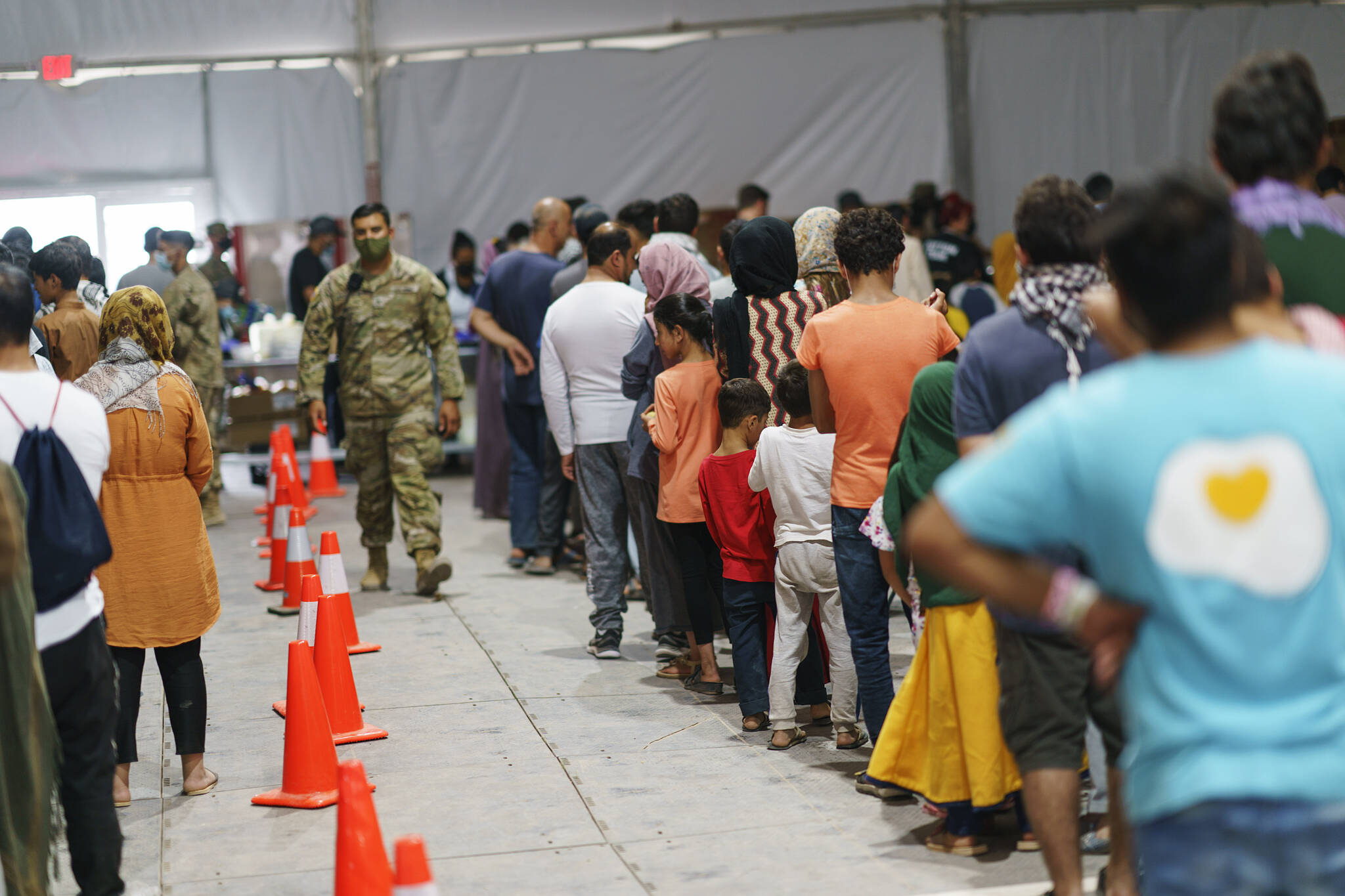 Afghan refugees line up for food in a dining hall at Fort Bliss’ Doña Ana Village, in New Mexico, where they are being housed, Friday, Sept. 10, 2021. Between 50 to 100 Afghans refugees are set to relocate to Alaska through the Catholic Social Services Refugee Assistance and Immigration Services’ resettlement program in Anchorage. (AP Photo/David Goldman)