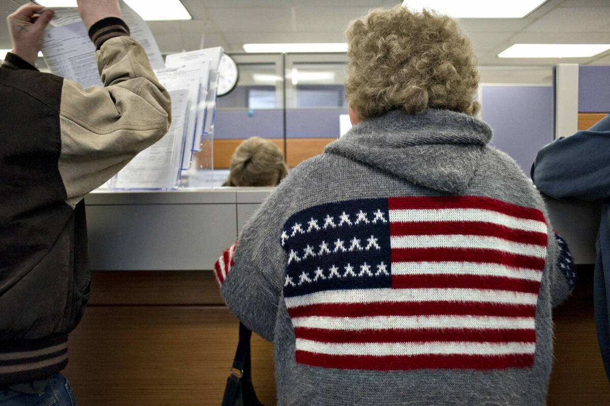 Alaskans pick up and turn in Permanent Fund Dividend applications at the Department of Revenue office in the State Office Building in March 2011. (Michael Penn / Juneau Empire File)