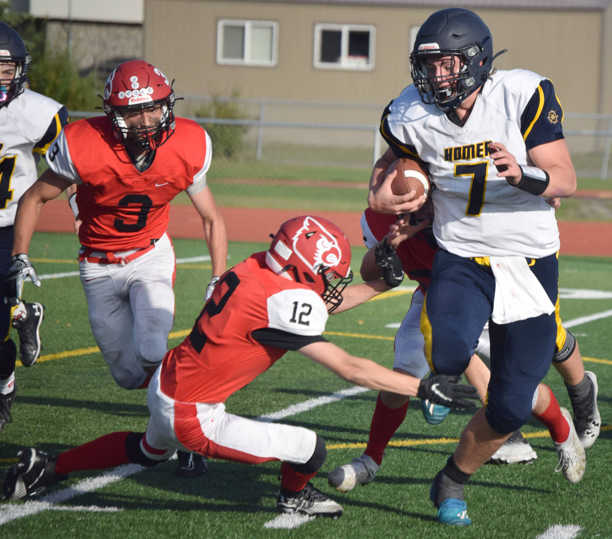 Homer quarterback Carter Tennison tries to avoid the tackle of Kenai Central’s Talon Whicker on Friday, Sept. 17, 2021, at Ed Hollier Field in Kenai, Alaska. (Photo by Jeff Helminiak/Peninsula Clarion)