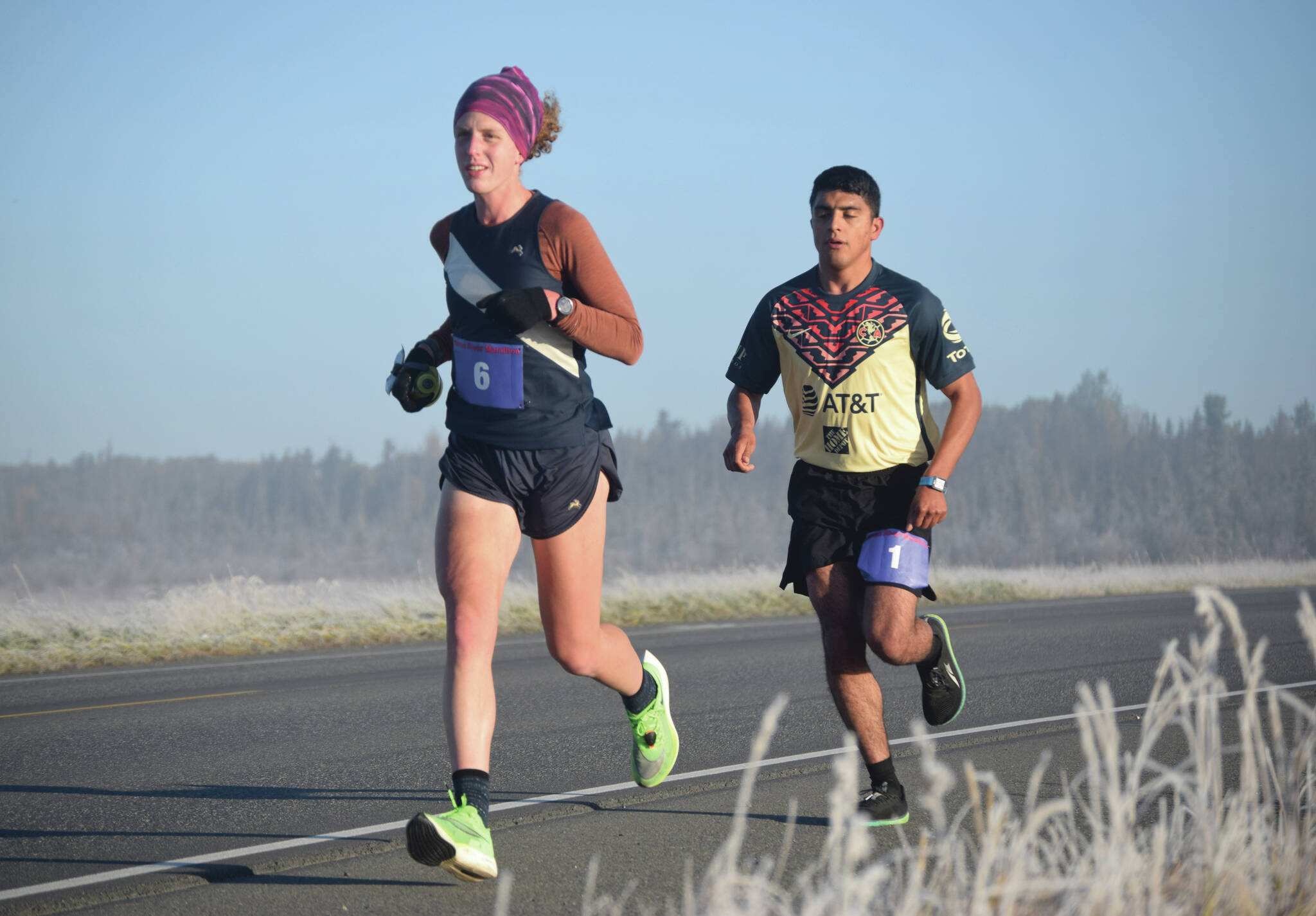 Women’s marathon winner Megan Youngren and men’s marathon winner Pedro Ochoa run on Bridge Access Road during the Kenai River Marathon on Sunday, Sept. 26, 2021, in Kenai, Alaska. (Photo by Jeff Helminiak/Peninsula Clarion)