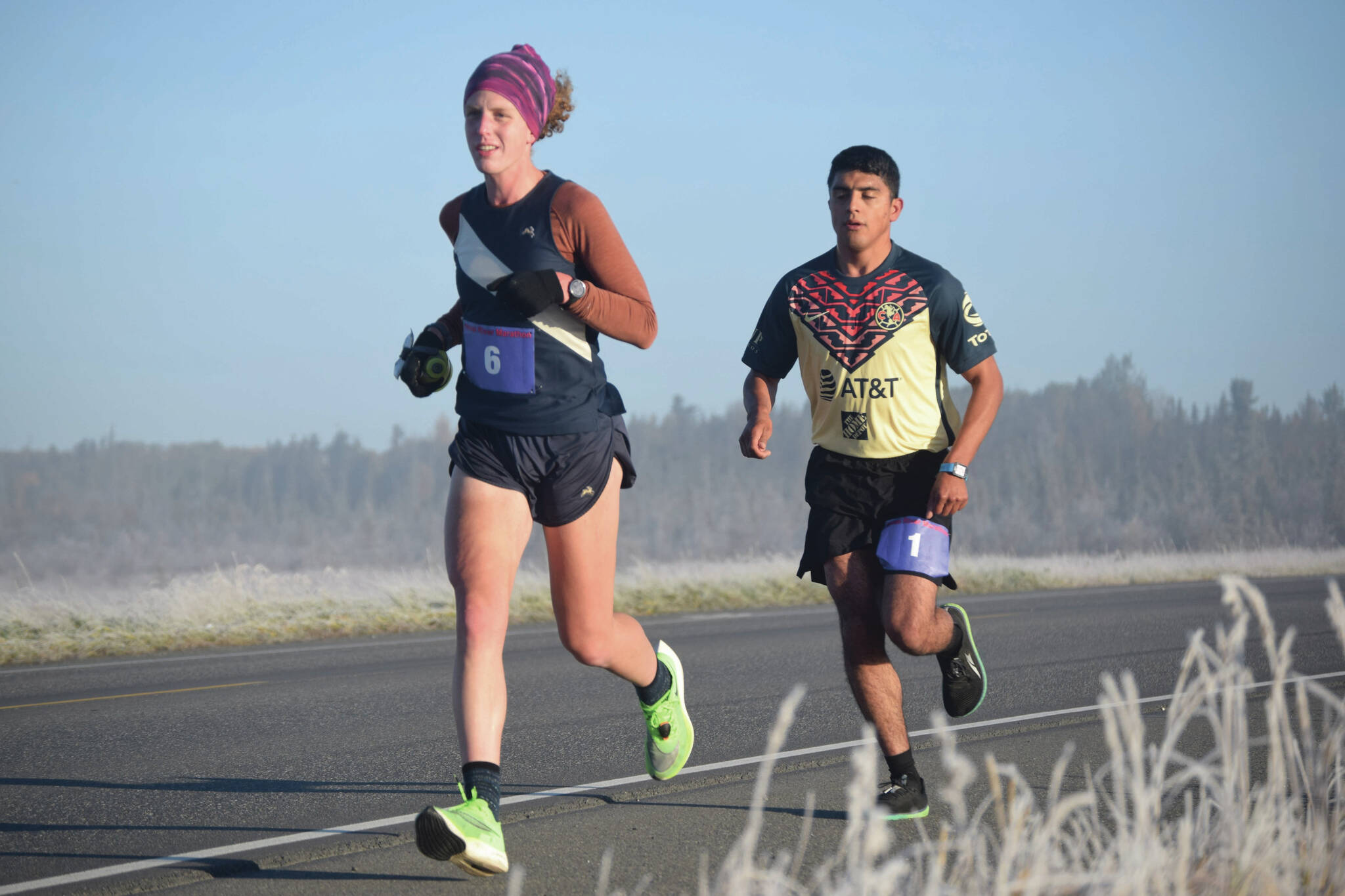 Women's marathon winner Megan Youngren and men's marathon winner Pedro Ochoa run on Bridge Access Road during the Kenai River Marathon on Sunday, Sept. 26, 2021, in Kenai, Alaska. (Photo by Jeff Helminiak/Peninsula Clarion)