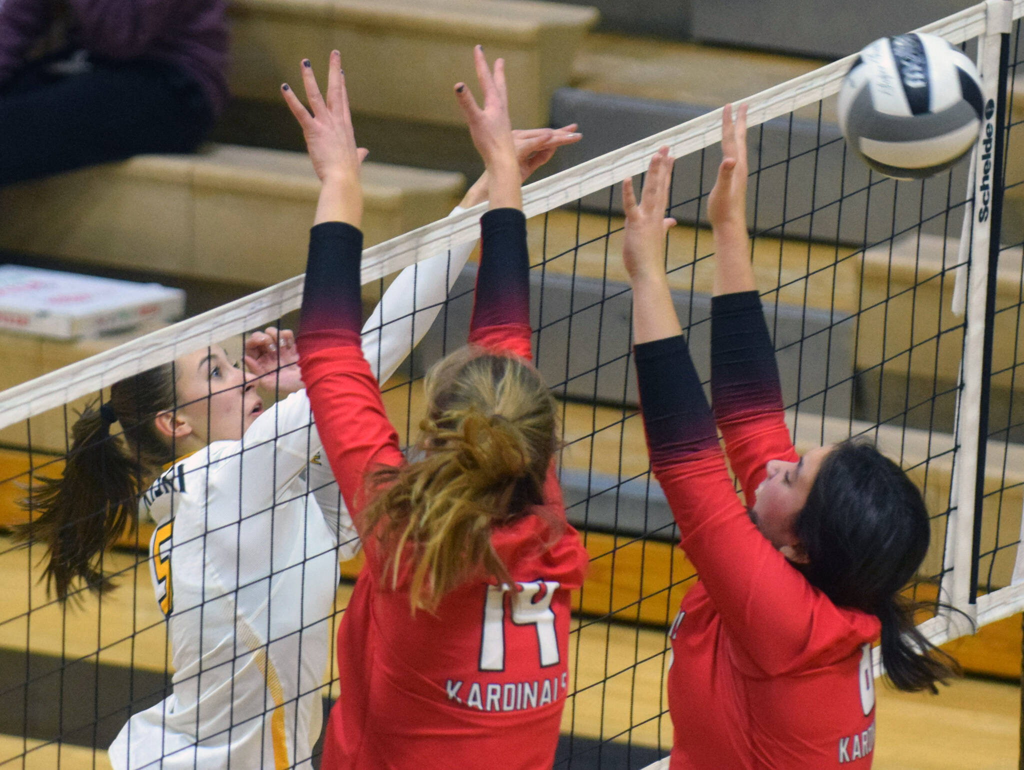 Nikiski's Rylee Ellis puts the ball between Kenai blockers Erin Koziczkowski and Jorgi Phillips during their volleyball game on Tuesday, Sept. 28, 2021, in Nikiski, Alaska. (Camille Botello/Peninsula Clarion)