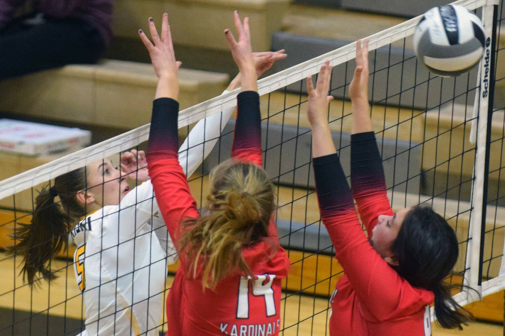 Nikiski's Rylee Ellis puts the ball between Kenai blockers Erin Koziczkowski and Jorgi Phillips during their volleyball game on Tuesday, Sept. 28, 2021, in Nikiski, Alaska. (Camille Botello/Peninsula Clarion)