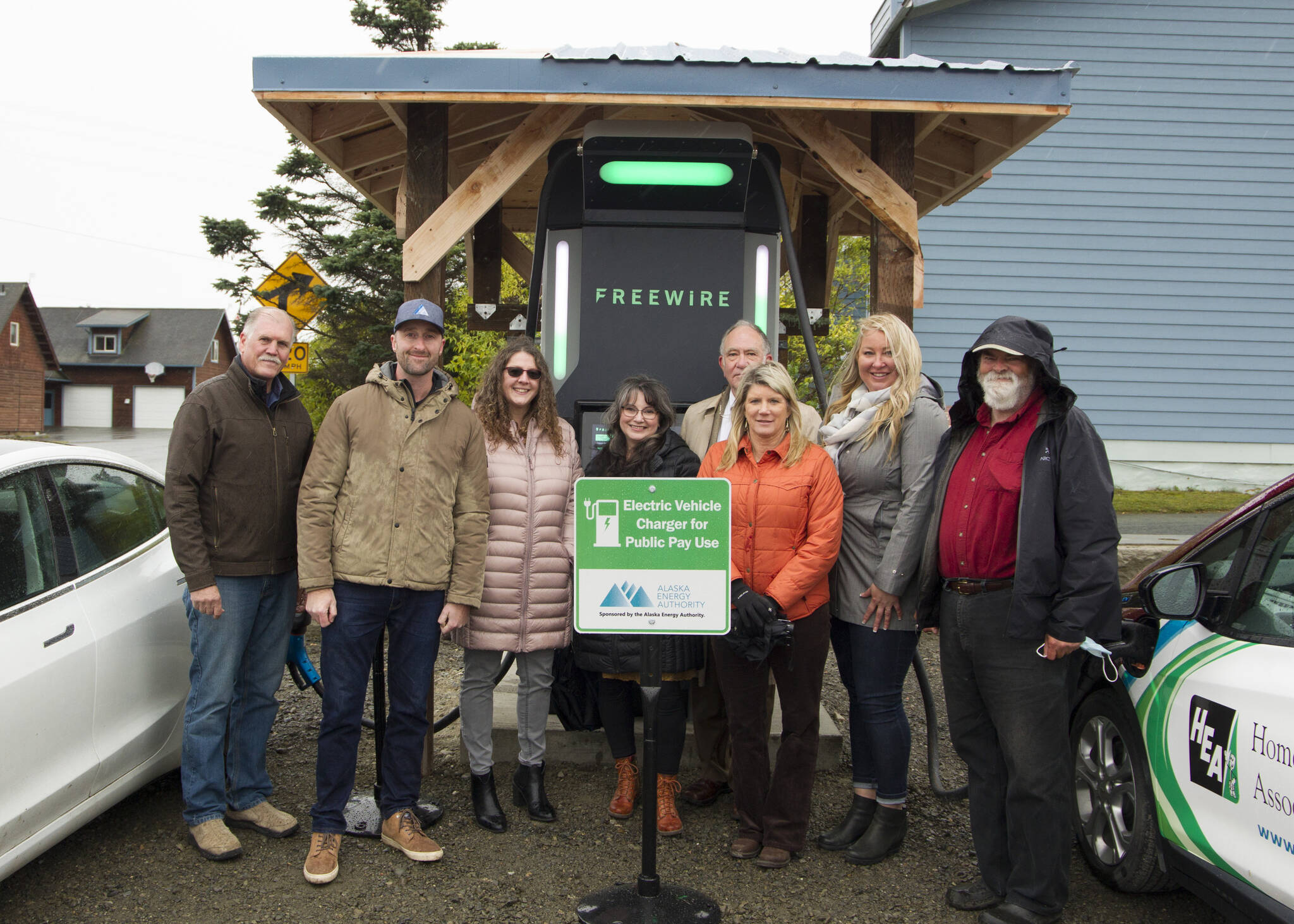 Community and state representatives responsible for bringing the fast-charging station to Homer pose for a photo in front of the station. (Photo by Sarah Knapp/Homer News)