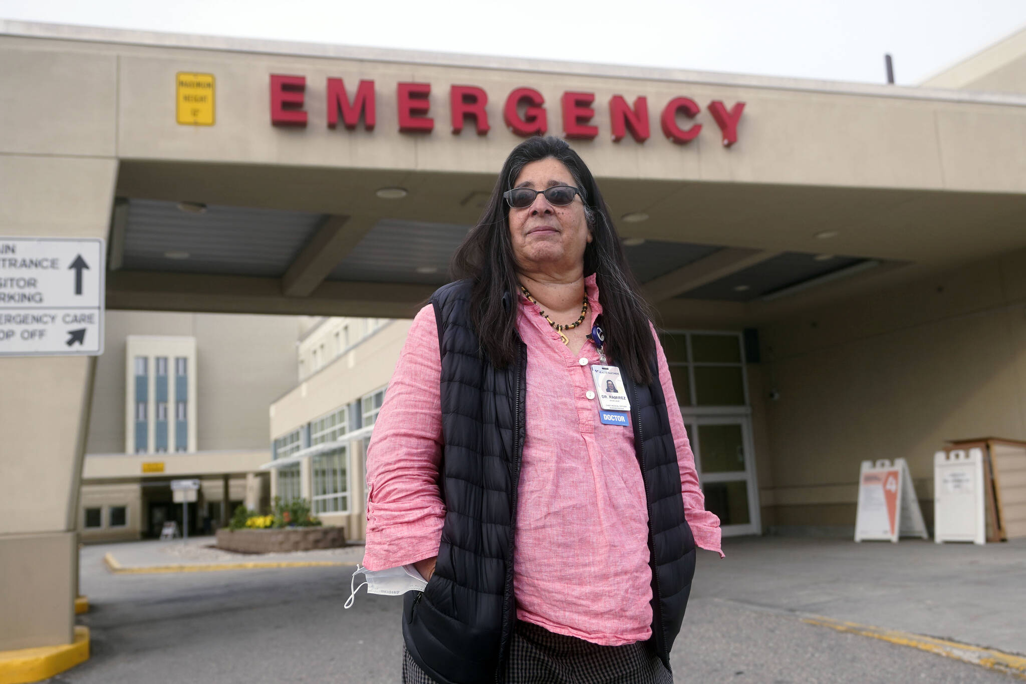 Angelique Ramirez, chief medical officer at Foundation Health Partners in Fairbanks, poses for a photograph in front of the emergency entrance at Fairbanks Memorial Hospital on Tuesday, Sept. 21, 2021, in Fairbanks, Alaska. Fairbanks Memorial Hospital on Friday, Oct. 1, said it activated the Crisis Standards of Care policy because of a critical shortage of bed capacity, staffing and monoclonal antibody treatments, along with the inability to transfer patients to other facilities. (AP Photo/Rick Bowmer)