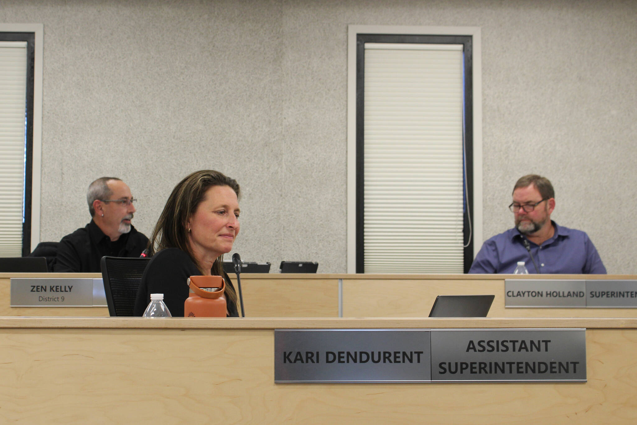 Kenai Peninsula Borough School District Assistant Superintendent Kari Dendurent (front left) and Superintendent Clayton Holland (back right) listen as Board of Education President Zen Kelly (back left) speaks at a board meeting on Monday in Soldotna. (Ashlyn O’Hara/Peninsula Clarion)