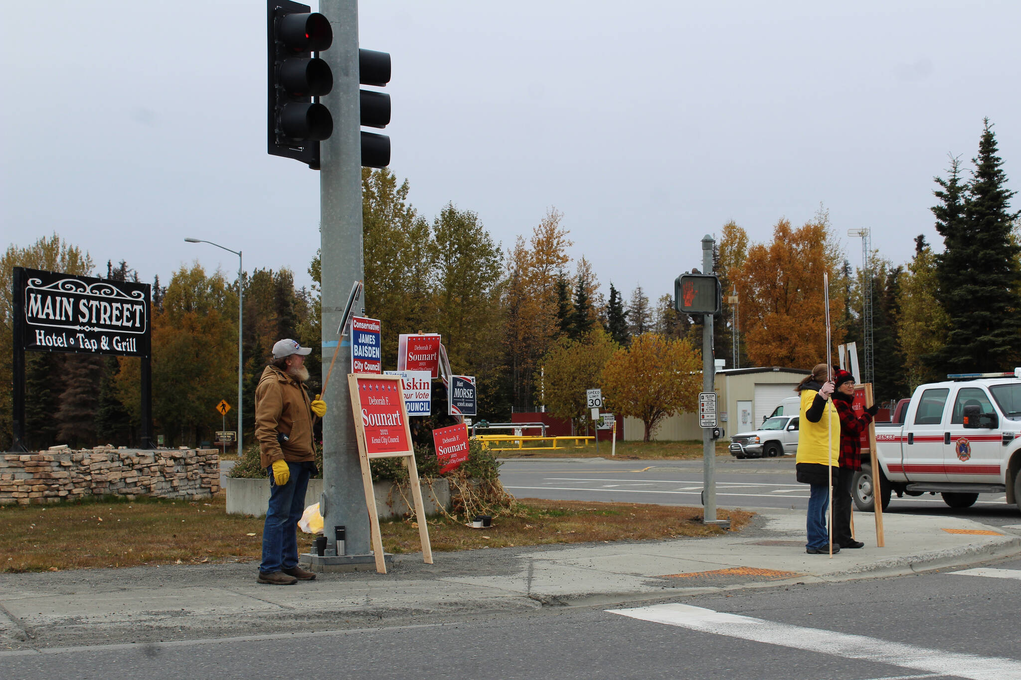 People waive signs at the intersection of Kenai Spur Highway and Main Street Loop on Tuesday, Oct. 5, 2021 in Kenai, Alaska.(Ashlyn O’Hara/Peninsula Clarion)