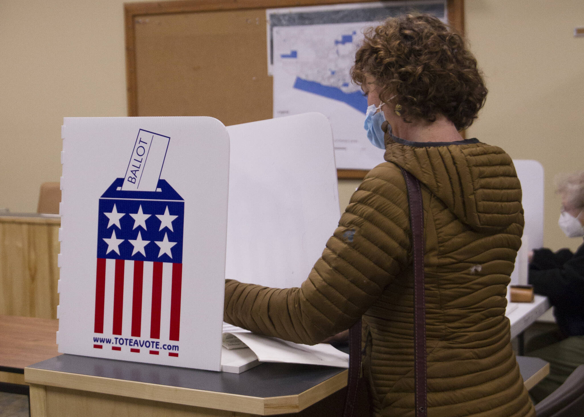 A voter at city hall reviews their ballot before submitting it on Oct. 5. (Photo by Sarah Knapp/Homer News)