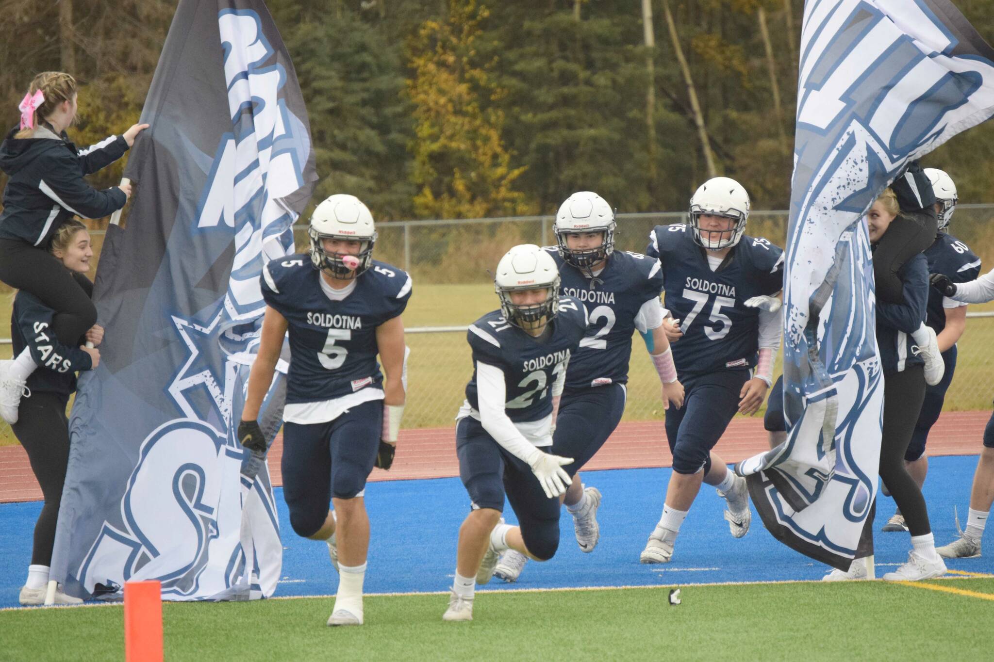 Brock Wilson and Brayden Taylor lead Soldotna onto Justin Maile Field for a Division II semifinal against North Pole on Friday, Oct. 8, 2021, in Soldotna, Alaska. (Photo by Jeff Helminiak/Peninsula Clarion)