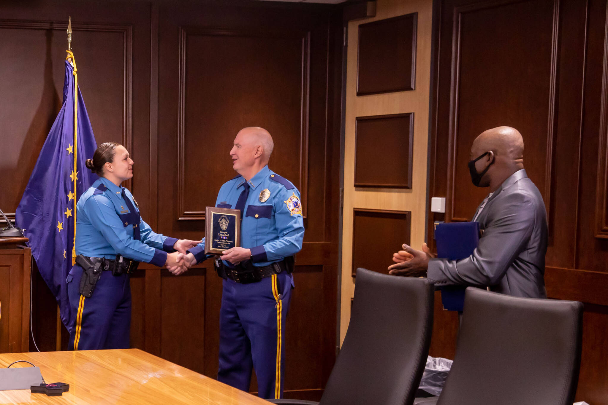 Department of Public Safety Commissioner James Cockrell (center) presents Wildlife Trooper Laura Reid (left) with a Life-Saving Award for her efforts in rescuing a child from the Kenai River offshore of North Kenai Beach this summer, during a ceremony held by Gov. Mike Dunleavy on Oct. 13, 2021. Reid and Kenai River dipnetter Antoine Aridou (far right) rescued the 12-year-old on July 29, 2021. (Photo provided by the Office of the Governor)