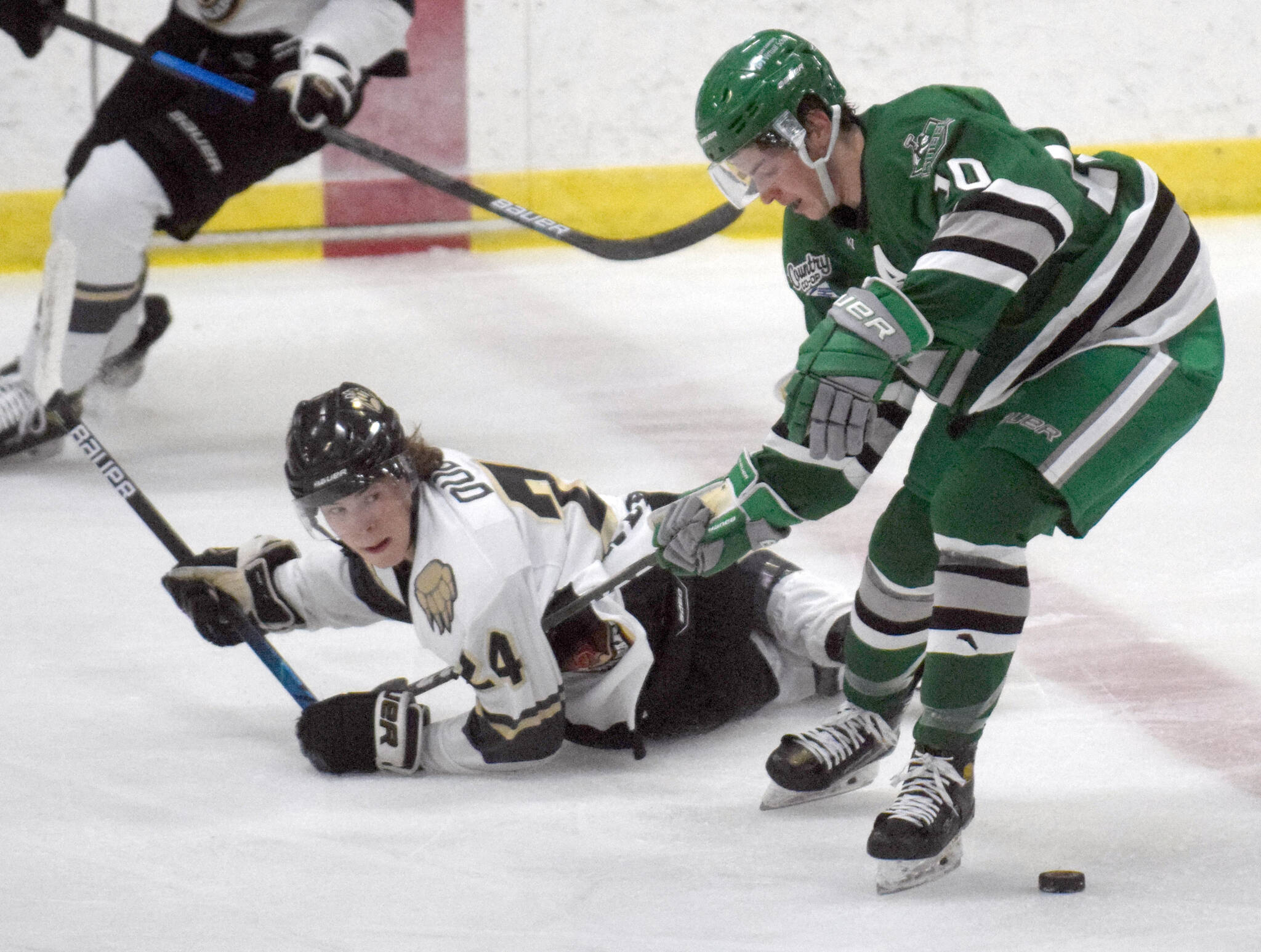 Brown Bears forward Cole Dubicki and Chippewa (Wisconsin) Steel forward Ethan Benz tangle for the puck Thursday, Oct. 21, 2021, at the Soldotna Regional Sports Complex. (Photo by Jeff Helminiak/Peninsula Clarion)