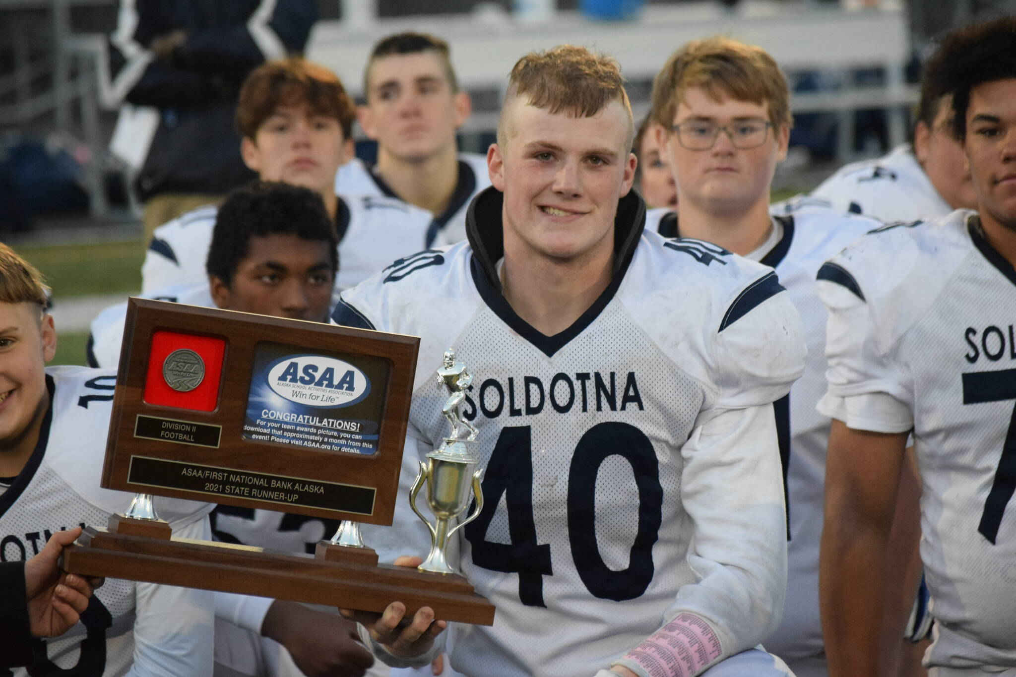 Soldotna senior Dylan Dahlgren accepts the team’s runner-up award after the Division II state football championship game against Lathrop at Service High School in Anchorage on Saturday, Oct. 16, 2021.(Camille Botello/Peninsula Clarion)
