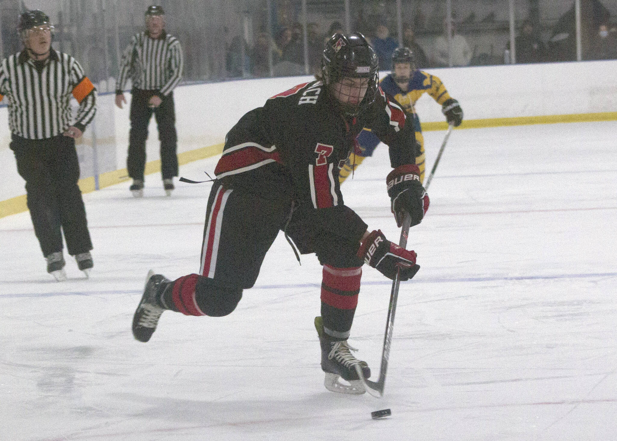 Kenai Central’s Jacob Begich moves the puck against Homer on Friday, Nov. 6, 2021, at the Kevin Bell Arena in Homer, Alaska. (Photo by Sarah Knapp/Homer News)