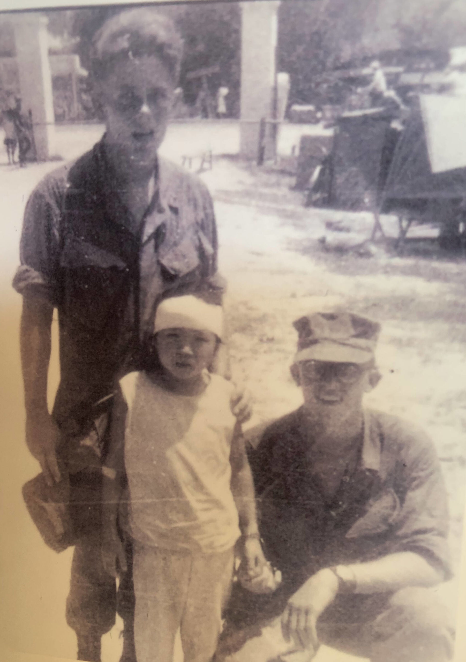 Cpl. Gary Squires kneals next to a young Vietnamese girl he helped rescue and the doctor who bandaged her wounds. (Photo provided by Gary Squires)