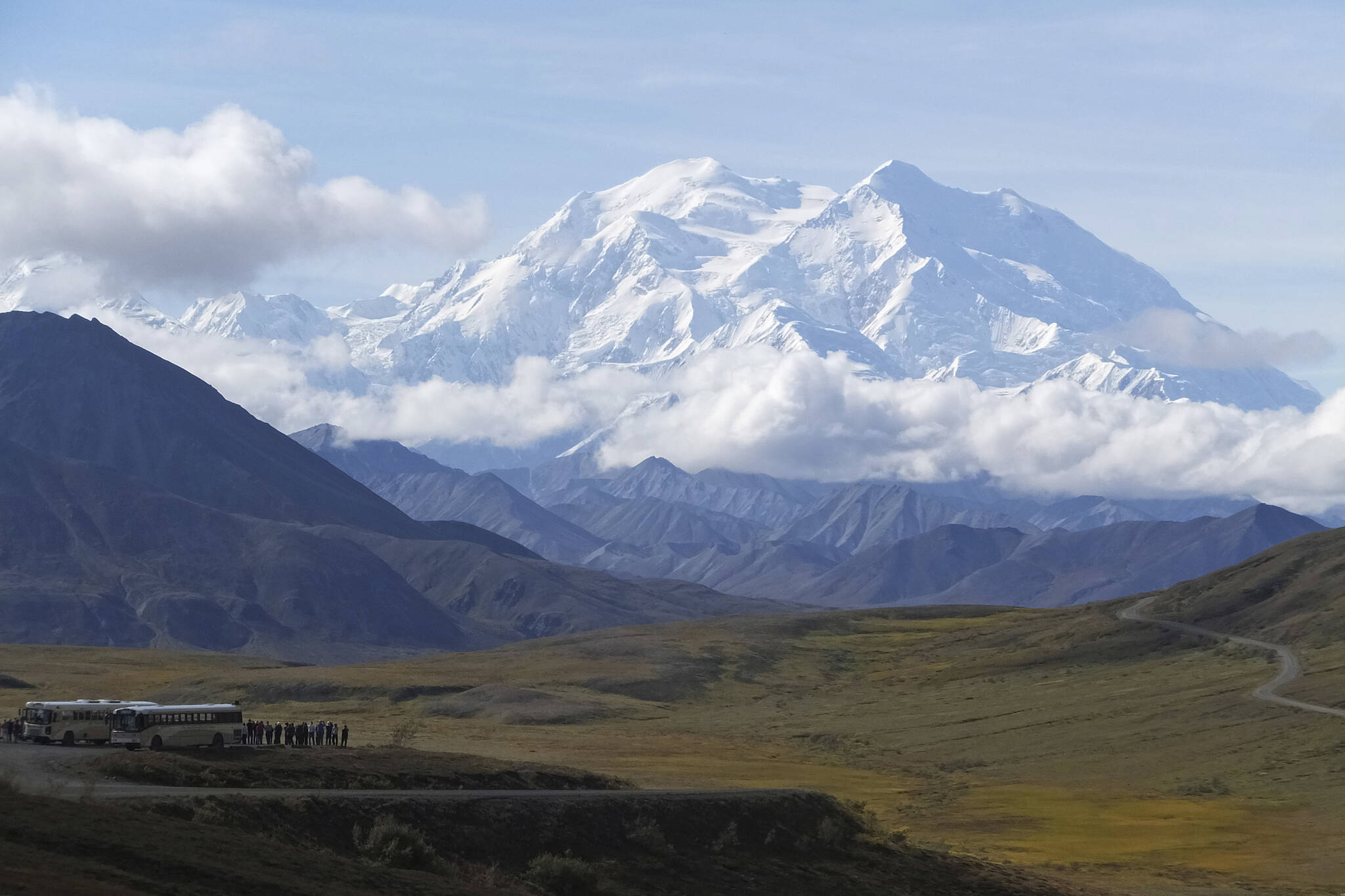 Sightseeing buses and tourists are seen at a pullout popular for taking in views of North America’s tallest peak, Denali, in Denali National Park and Preserve, Alaska, on Aug. 26, 2016. A Utah doctor is accused of lying to get a high-elevation helicopter to rescue him off the tallest mountain in North America and then destroying evidence. Dr. Jason Lance, who is a radiologist in Ogden, Utah, faces three misdemeanors, interfering with and violating the order of a government employee and for filing a false report from his May 2021, attempt to summit Denali, located about 180 miles north of Anchorage. (AP Photo/Becky Bohrer, File)