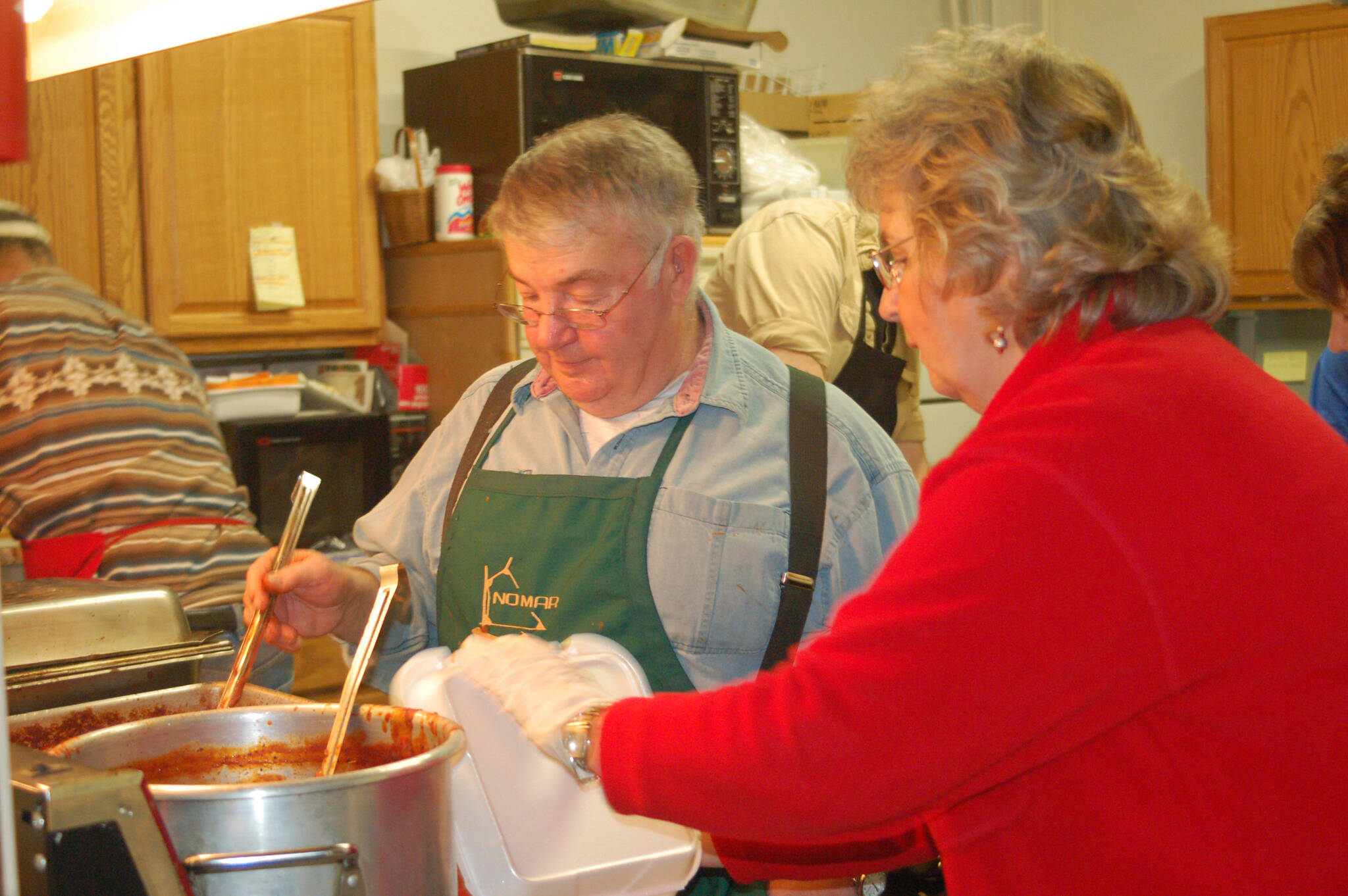Homer News Ben Mitchell, left, serves spaghetti to helper Pat Wells in the kitchen at a past Share the Spirit spaghetti feed. (Michael Armstrong/Homer News file)
