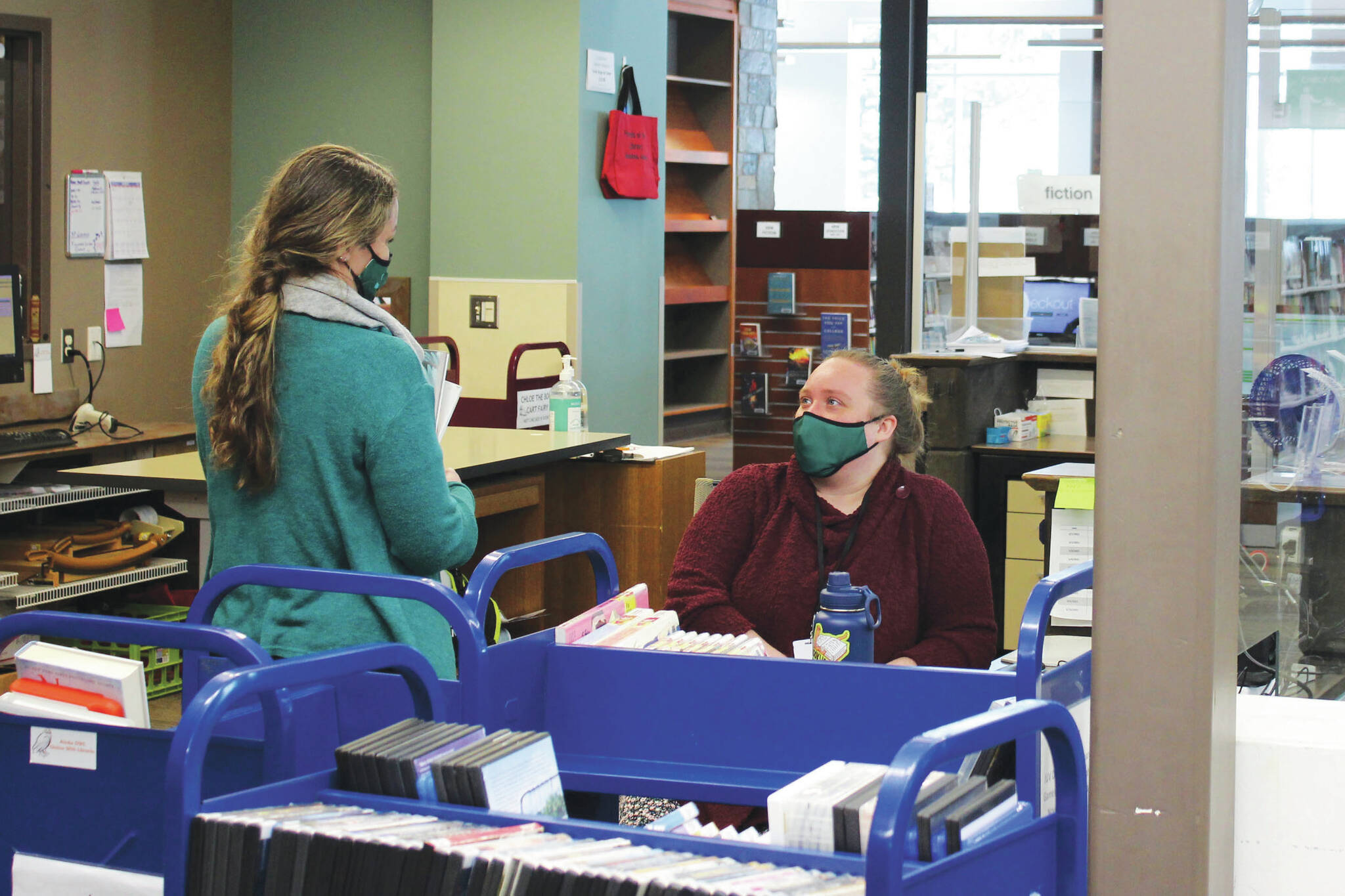Ryanna Thurman (right) speaks to a library employee at the Soldotna Public Library on Thursday, March 25 in Soldotna, Alaska. (Ashlyn O’Hara/Peninsula Clarion)
