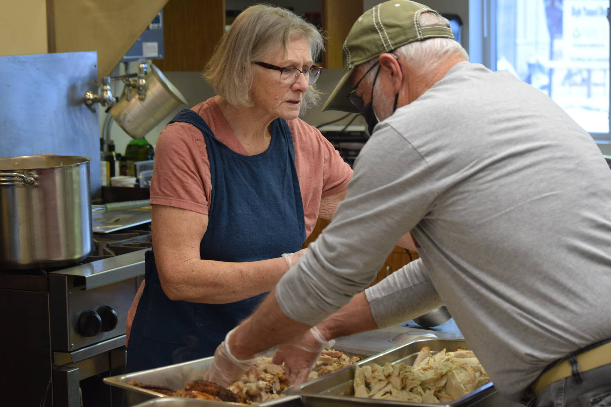 Cheryl Morse and Tom Kleeman prepare Thanksgiving lunch at the Kenai Peninsula Food Bank on Wednesday, Nov. 24, 2021. (Camille Botello/Peninsula Clarion)