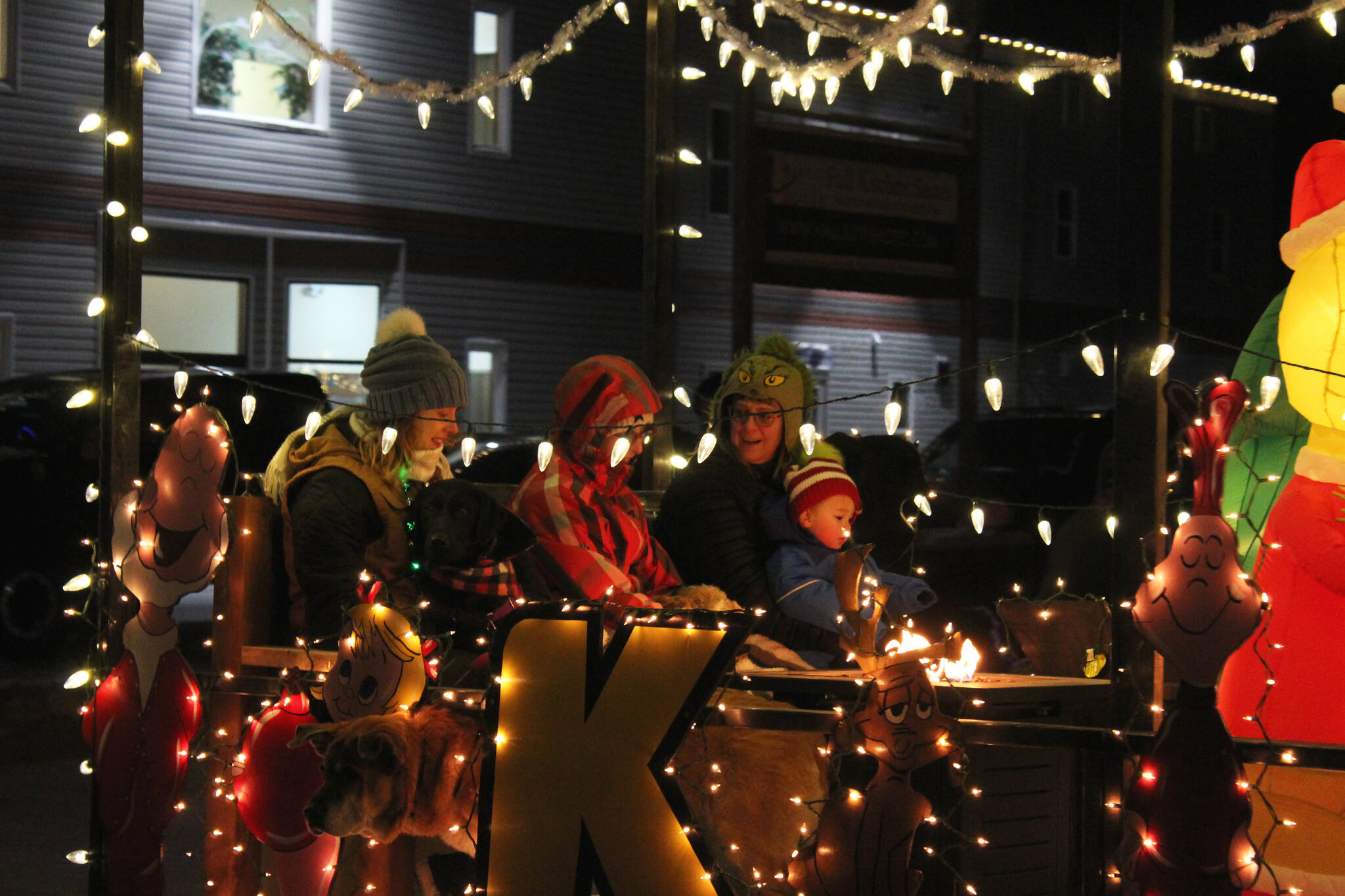 People sit on a float by Kendall Auto Group during the “Christmas Comes to Kenai” parade on Friday, Nov. 26, 2021 in Kenai, Alaska. (Ashlyn O’Hara/Peninsula Clarion)