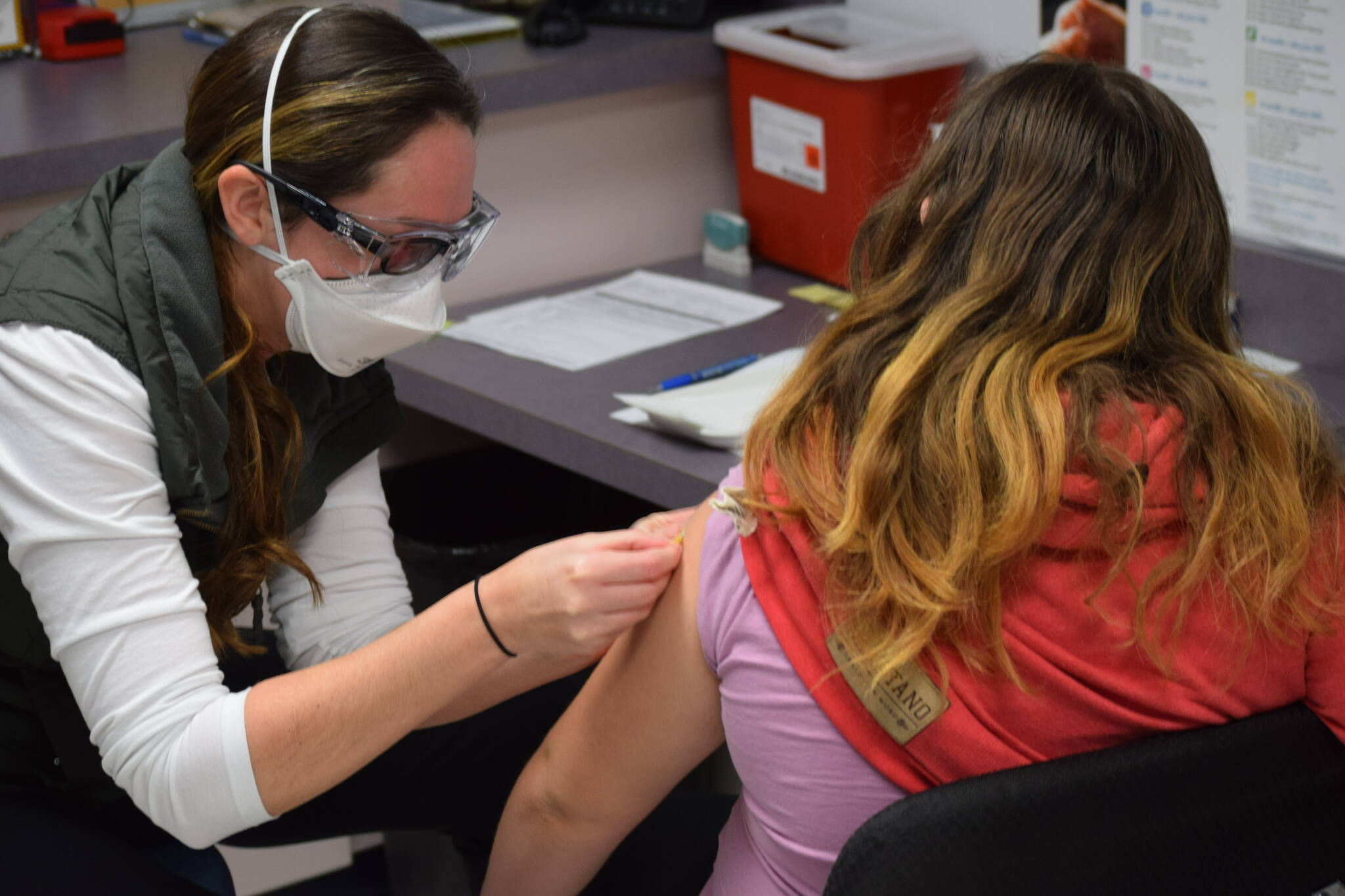 Nurse Sherra Pritchard gives Madyson Knudsen a bandage at the Kenai Public Health Center after the 10-year-old received her first COVID-19 vaccine on Friday, Nov. 5, 2021. (Camille Botello/Peninsula Clarion)