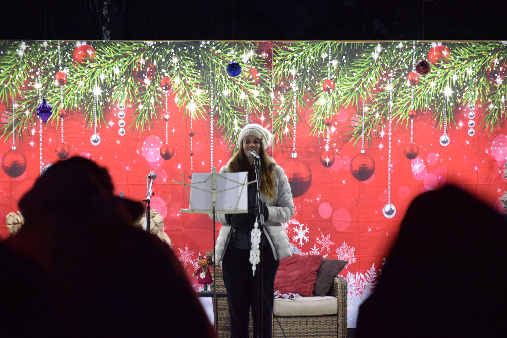 A member of the Soldotna High School swing choir sings carols for the crowd at Soldotna Creek Park on Saturday, Dec. 4, 2021. (Camille Botello/Peninsula Clarion)
