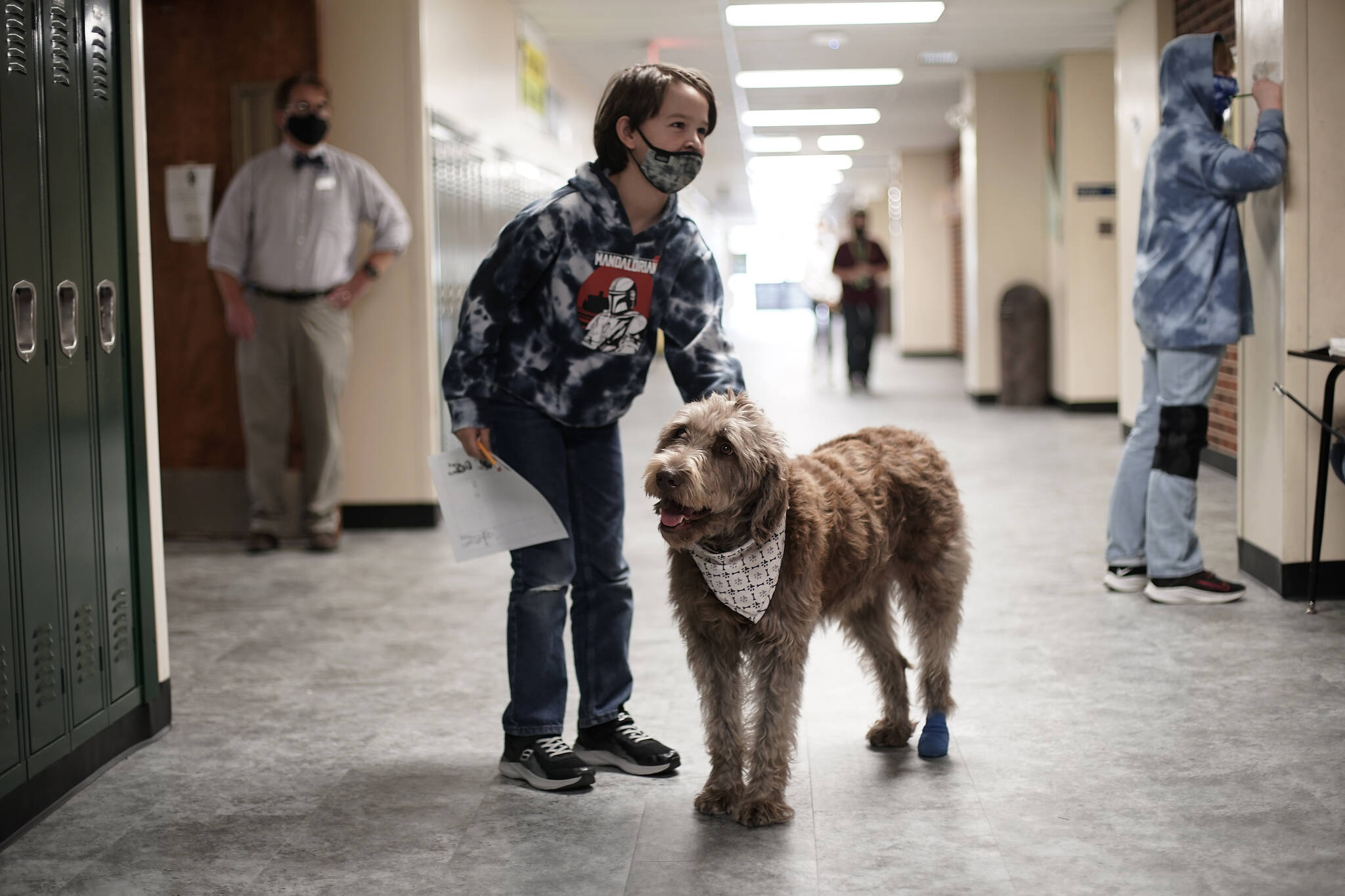 AP Photo/Charlie Riedel
A student pets Wilson, a therapy dog, in a hallway at French Middle School, Wednesday, Nov. 3, 2021, in Topeka, Kan. The dog is one of the tools designed to relieve stresses faced by students as they return to classrooms amid the ongoing pandemic. State health officials say nationwide trends in mental health issues are worse in Alaska.