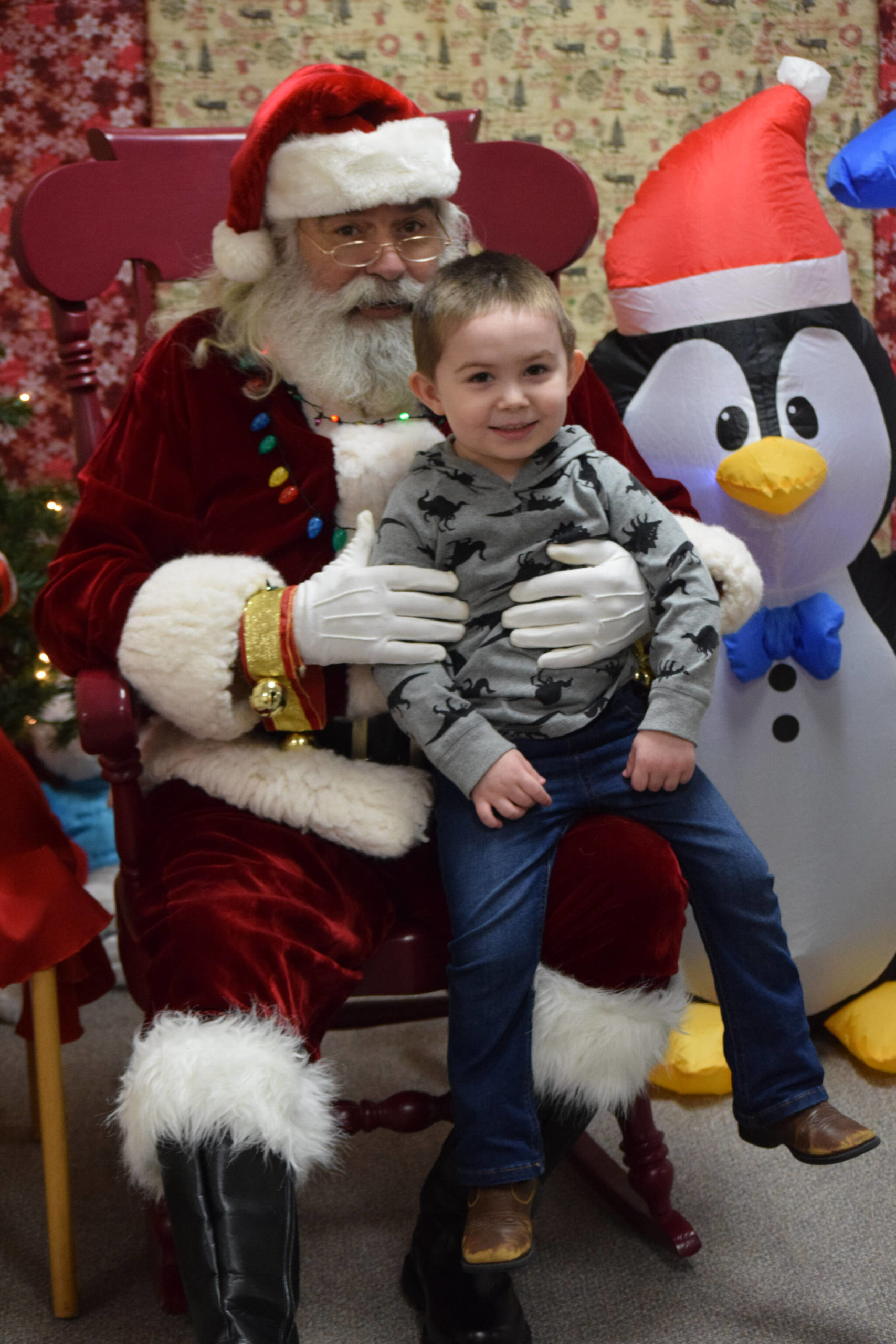 Brian Prather sits with Santa at the Nikiski Community Recreation Center on Saturday, Dec. 11, 2021, in Nikiski, Alaska. (Camille Botello/Peninsula Clarion)