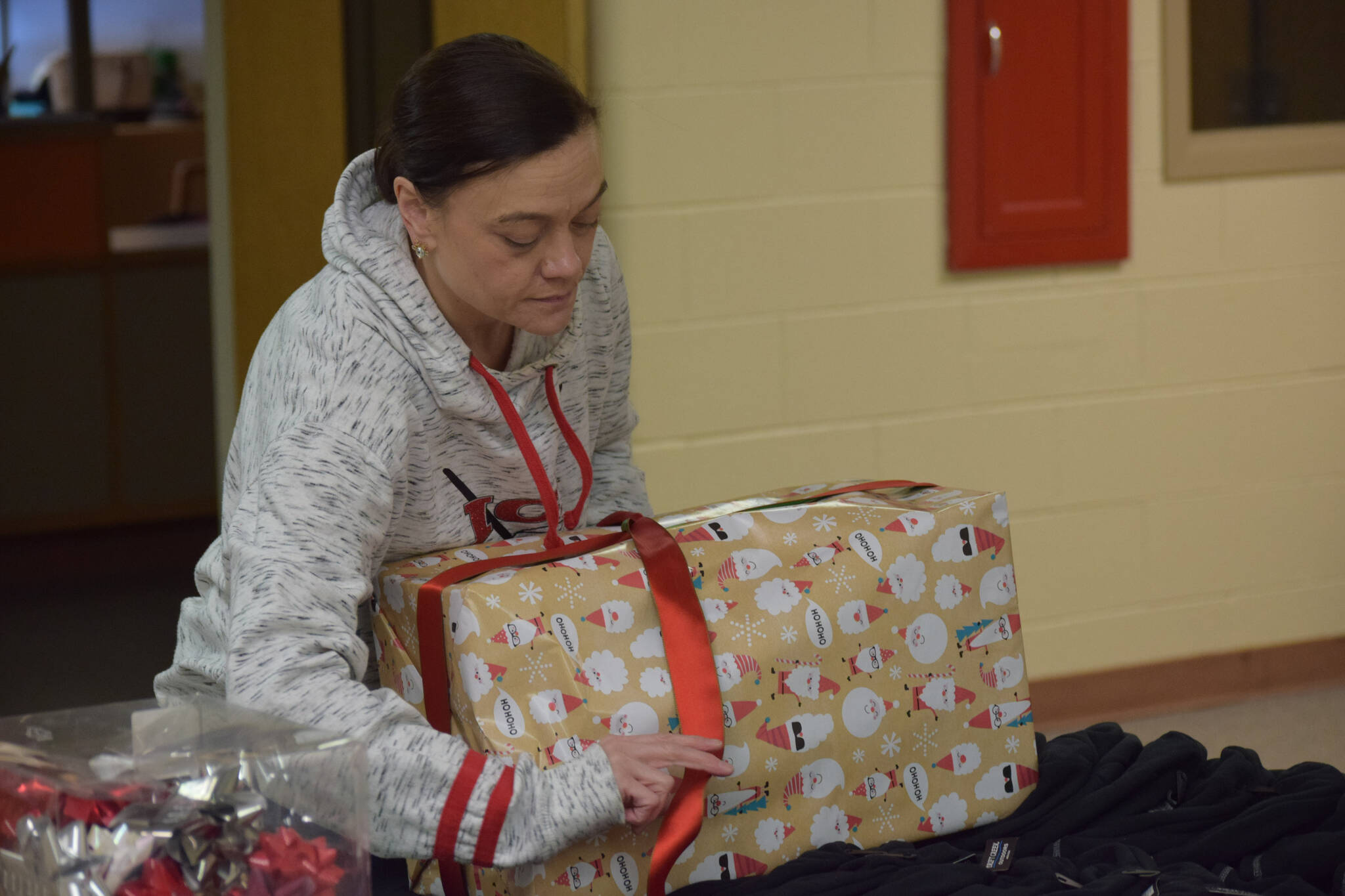 Sasha Fallon wraps gifts at the Nikiski Community Recreation Center on Saturday, Dec. 11, 2021, in Nikiski, Alaska. (Camille Botello/Peninsula Clarion)