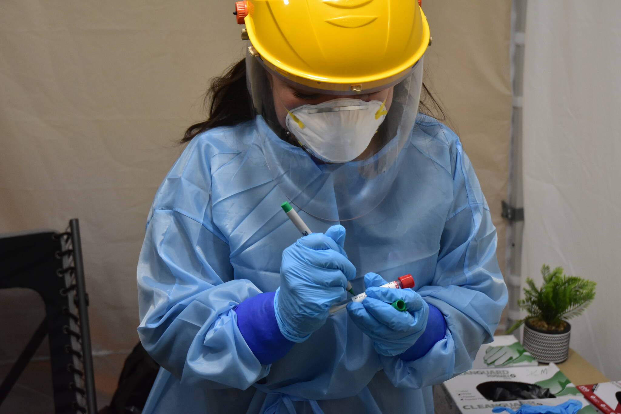 An emergency worker holds a COVID-19 test sample at the Juneau International Airport in Juneau, Alaska, in October 2020. (Peter Segall / Juneau Empire file)