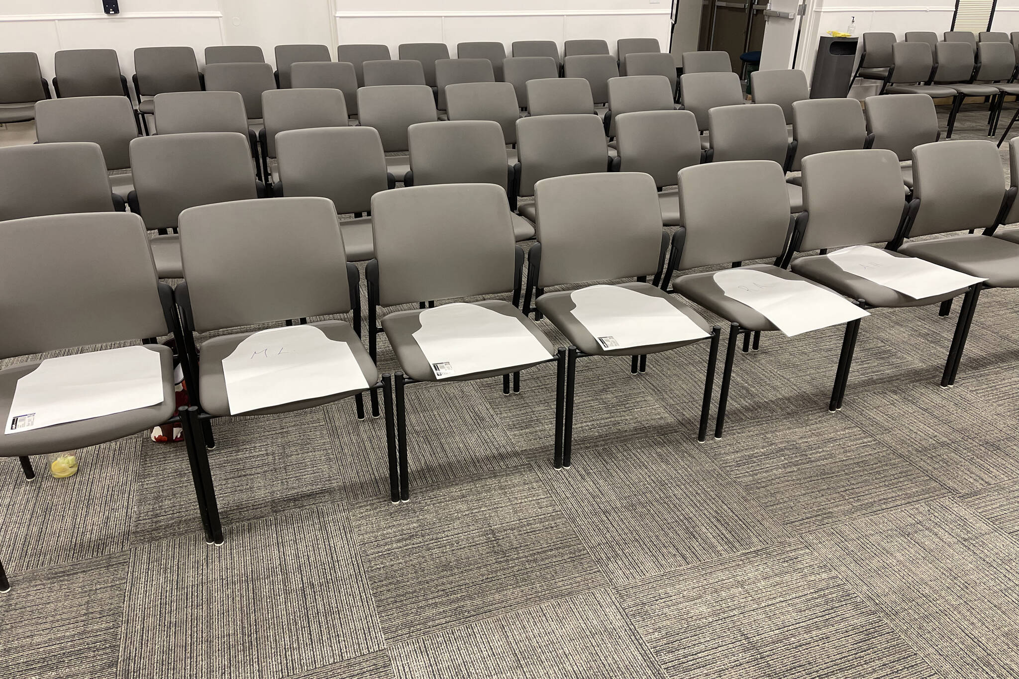 Chairs at the Kenai Peninsula Borough Assembly chambers are decorated with paper cutouts on Tuesday, Jan. 4, 2022, at the George A. Navarre Borough Admin Building in Soldotna, Alaska. The cutouts were intended to represent Central Peninsula Hospital patients who died of COVID-19. During public testimony given Tuesday, several members of the public expressed the desire for alternative treatments for COVID-19 and protested CPH’s treatment methods. (Photo courtesy Katherine Uei)