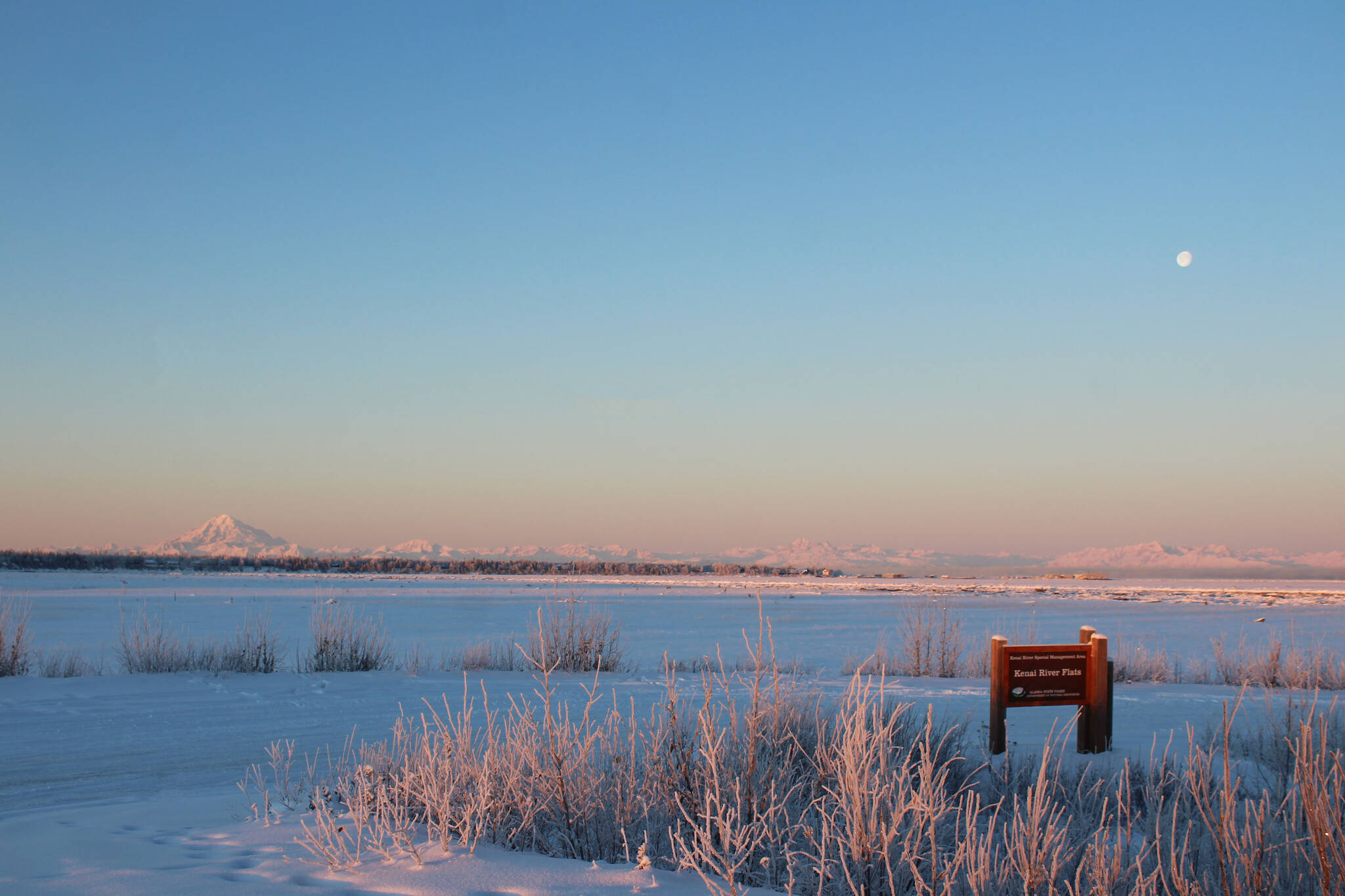 The moon sits above Mount Redoubt on Tuesday, Dec. 21, 2021 near Kenai, Alaska. (Ashlyn O’Hara/Peninsula Clarion)