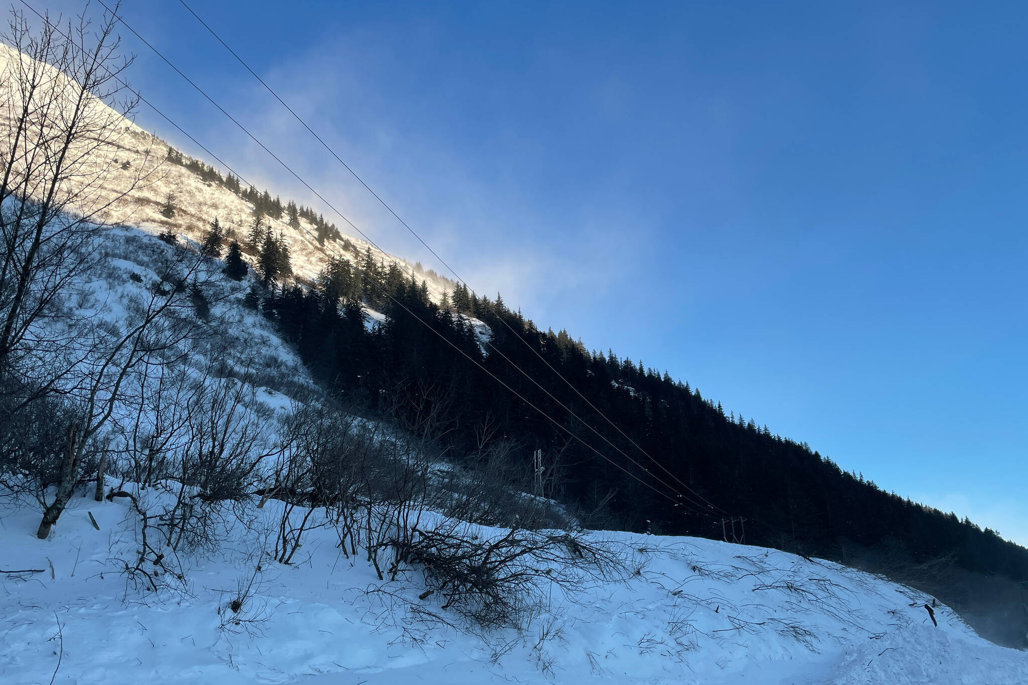 Snow blows off Mt. Roberts high above the Thane avalanche chute, where an avalanche blew across the road during a major snowstorm. (Michael S. Lockett / Juneau Empire)