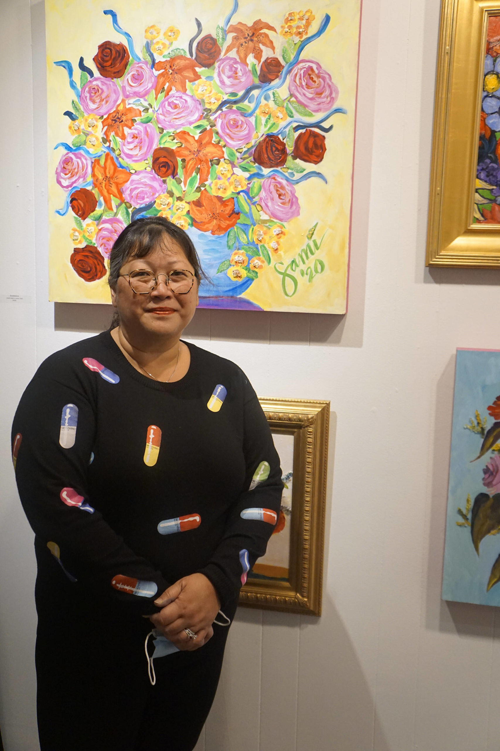 Dr. Sami Ali’s poses in front of some her paintings in her show, “The Mind of a Healthcare Worker During the COVID-19 Pandemic,” on Friday, Jan, 7, 2022, at the Homer Council on the Arts in Homer, Alaska. (Photo by Michael Armstrong/Homer News)