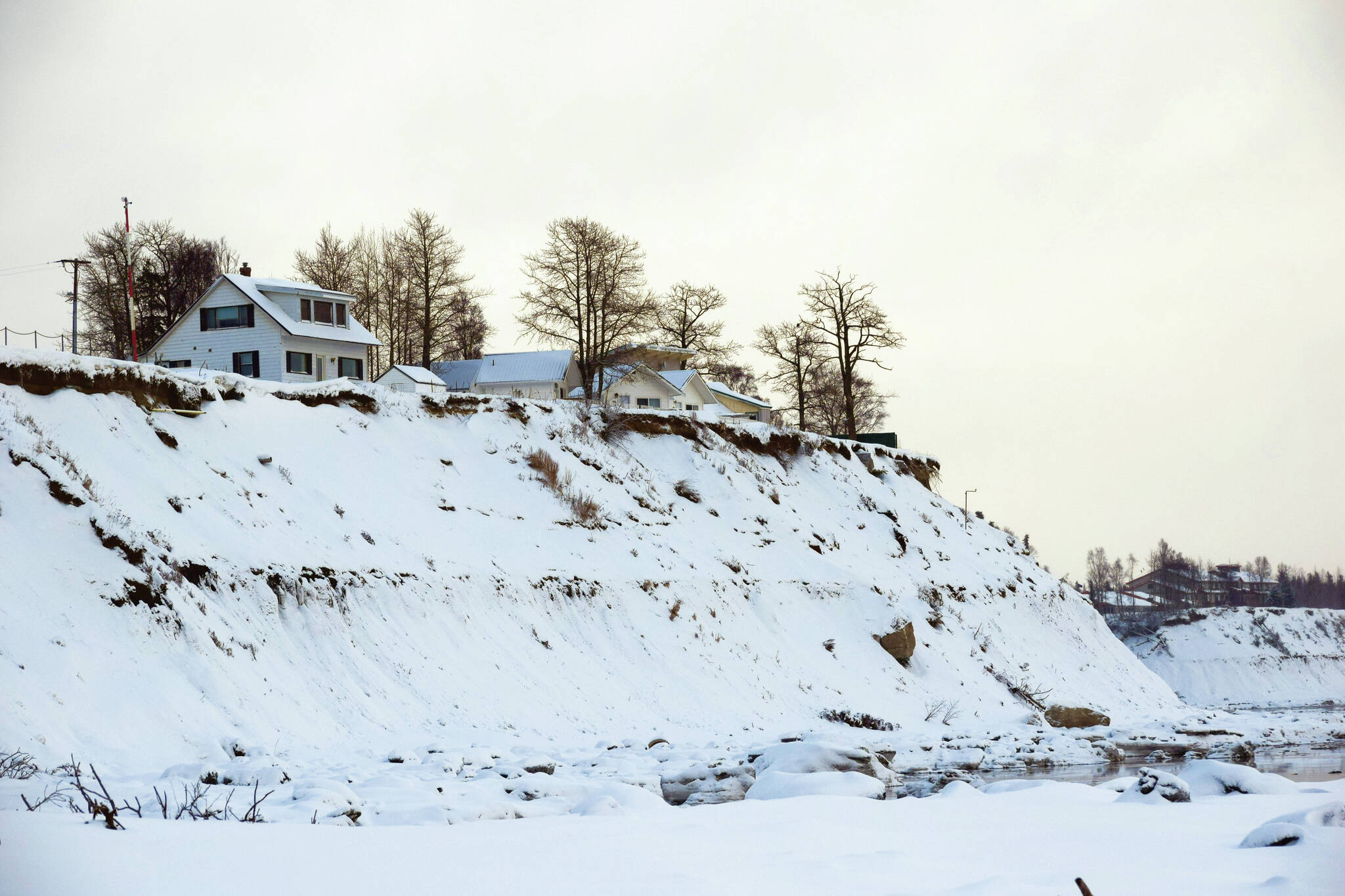 Camille Botello / Peninsula Clarion 
Buildings are perched above eroding bluffs on North Kenai Beach on Wednesday. The City of Kenai is receiving federal funds to address coastal erosion along sections of the bluff through the Infrastructure Investment and Jobs Act of 2021.