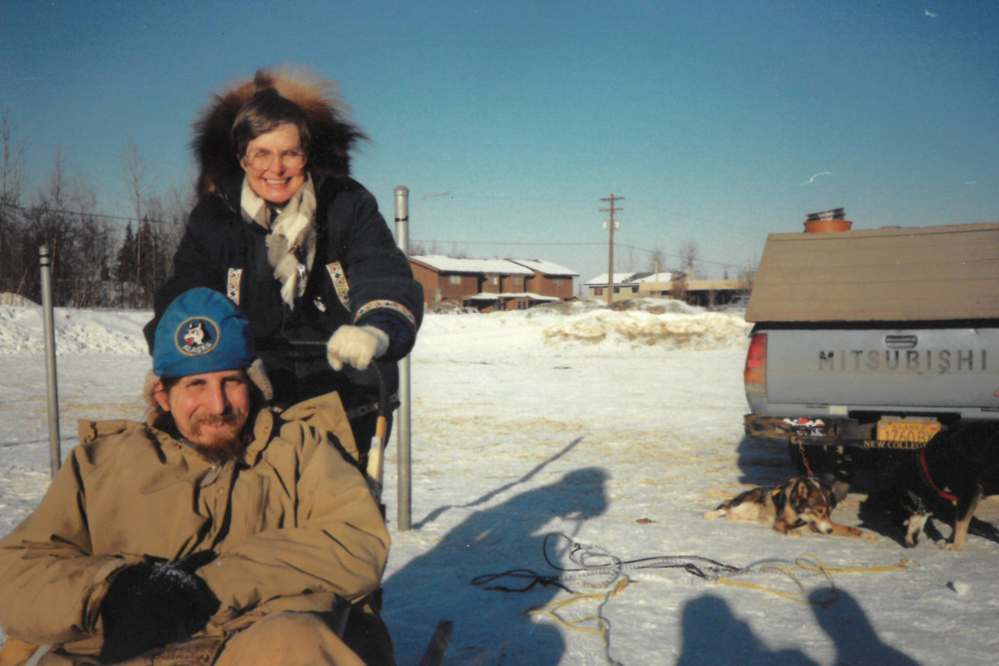Michael Armstrong, seated, in sled, gives his mother, Sylvia Jander, the unique Alaska experience of driving a sled-dog team in February 1989 in Anchorage, Alaska. (Photo by Jenny Stroyeck)