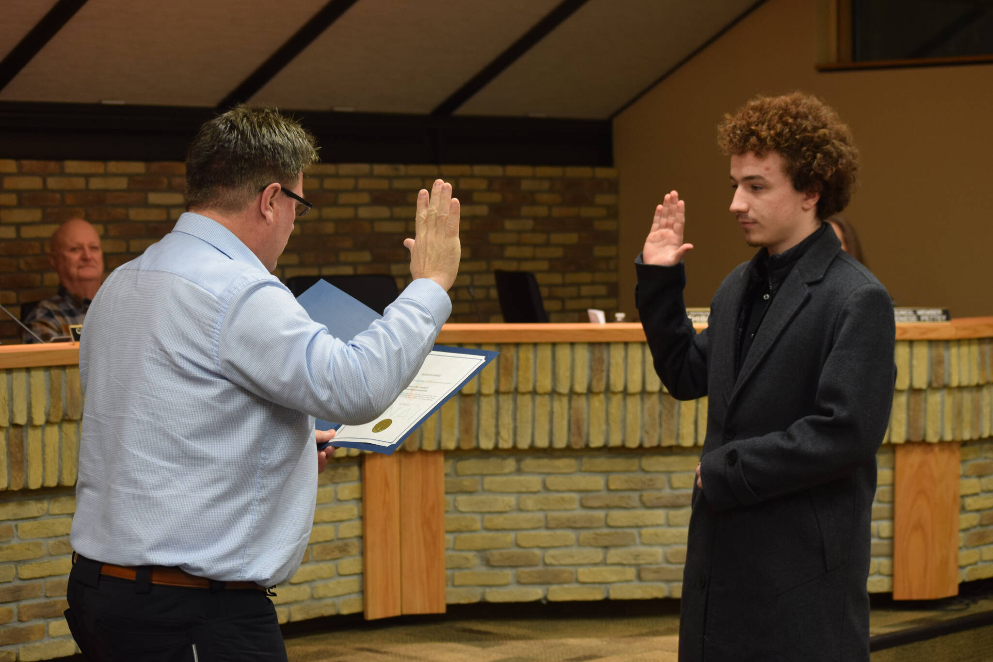 Kenai Mayor Brian Gabriel (left) swears in student representative Silas Thibodeau at the Kenai City Council meeting on Wednesday, Jan. 19, 2022. (Camille Botello/Peninsula Clarion)