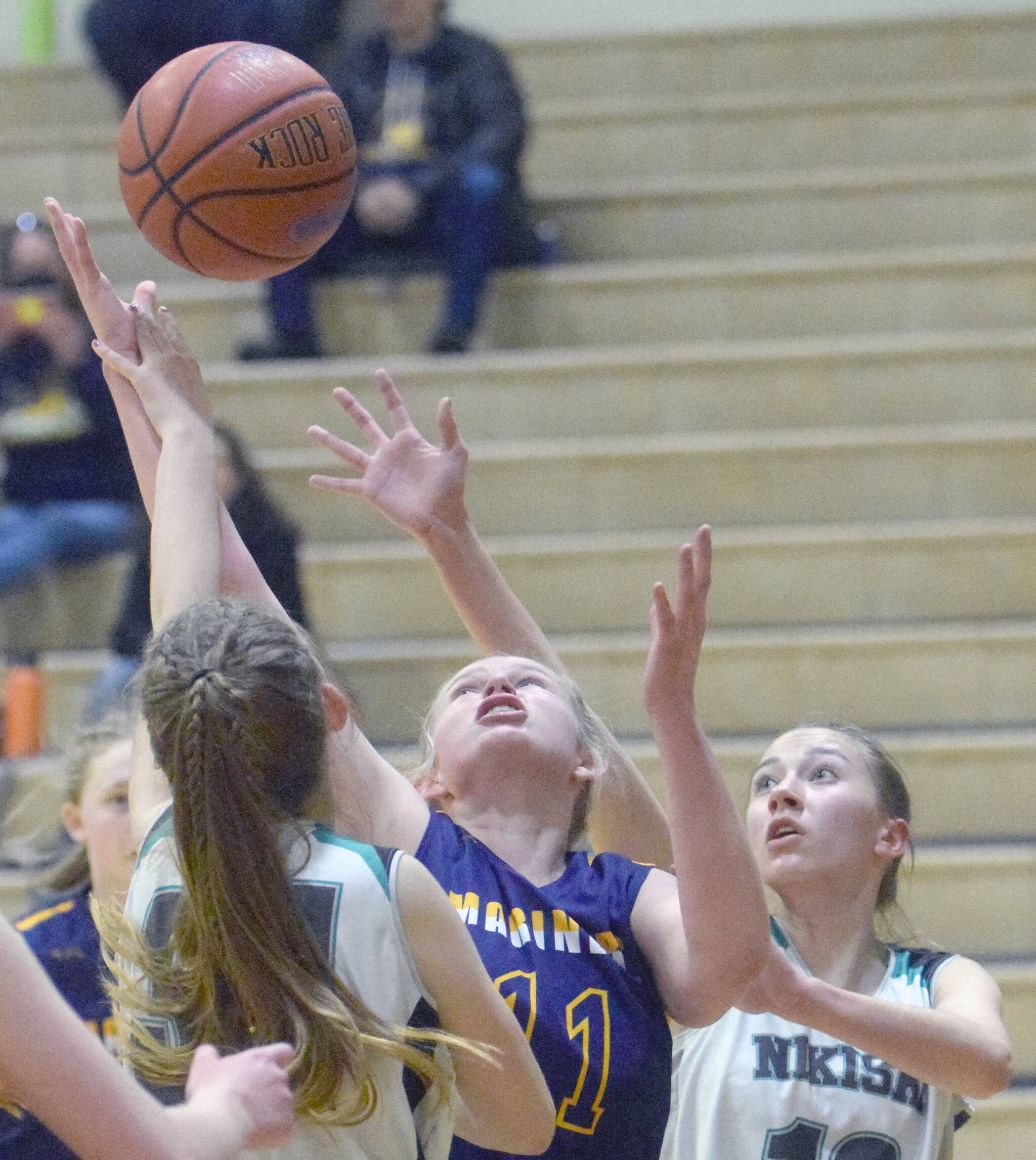 Homer’s Sydney Shelby fights for a rebound between Nikiski’s Shelby Burman and Rylee Ellis on Tuesday, Jan. 25, 2022, at Nikiski High School in Nikiski, Alaska. (Photo by Jeff Helminiak/Peninsula Clarion)