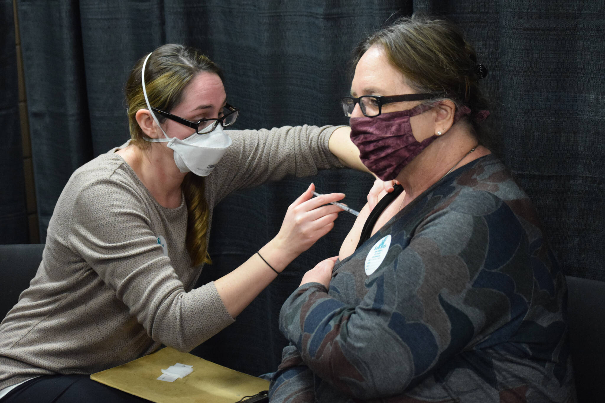 Kenai Public Health Nurse Sherra Pritchard gives Love Inc. Director Leslie Rohr a COVID-19 booster shot during the Project Homeless Connect event Soldotna Regional Sports Complex in Soldotna on Wednesday, Jan. 26, 2022. (Camille Botello/Peninsula Clarion)